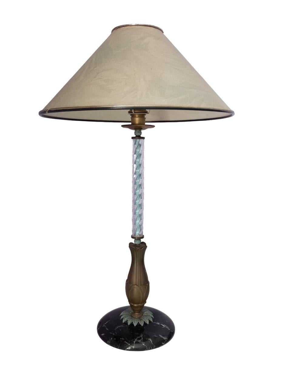 Lampada da tavolo con base in marmo e decoro con foglie in bronzo, stelo in vetro con riflessi di azzurro come i lievi decori del cappello. Italia anni ’50. 
Il paralume originale ha dei delicati disegni floreali sul verde acqua (molto