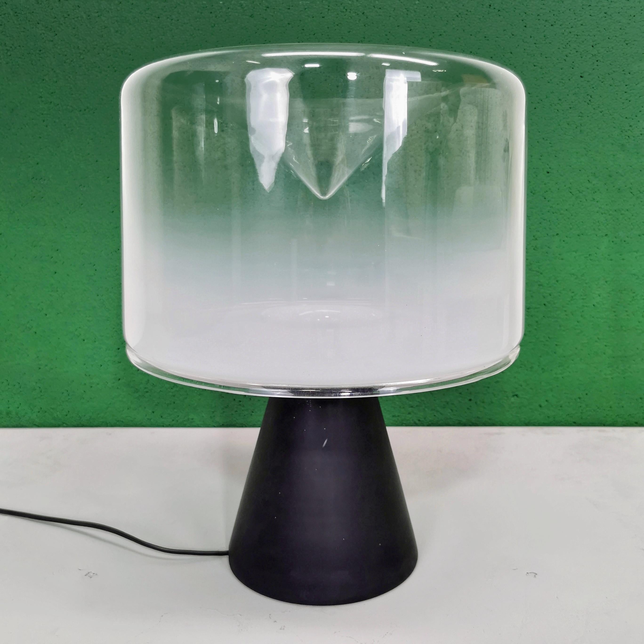 Large table lamp model Concerto designed in 1977 by Roberto Pamio for Leucos.
The diffuser is a large blown glass cylinder with conical recess, produced by Leucos in the best tradition of Murano glass.
Unique feature of this lamp is that the base is
