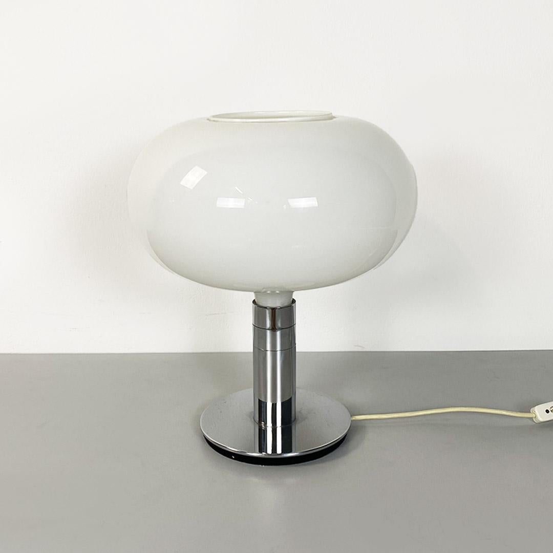 Table lamp from the AM/AS series, with a chrome-plated steel frame, with a round base and central stem six centimeters in diameter on which the tablet-shaped diffuser in white opaline glass is anchored, through a support that at the bottom screws