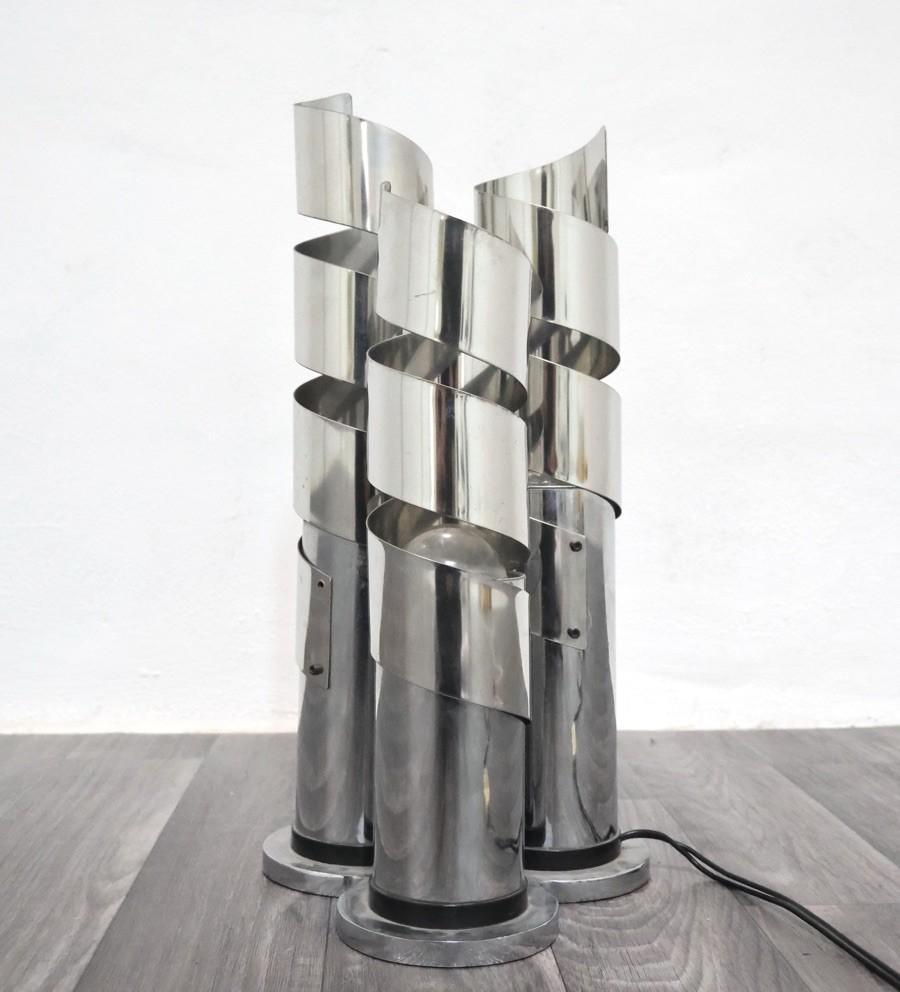 Lampe de table Design/One en acier chromé avec spirale - Attribuée à Max Sauze, Anni '70


Élégante lampe de table en acciaio cromato, caractérisée par un design raffiné en spirale qui fait évoluer la lumière dans un jeu de riffs et de géométries