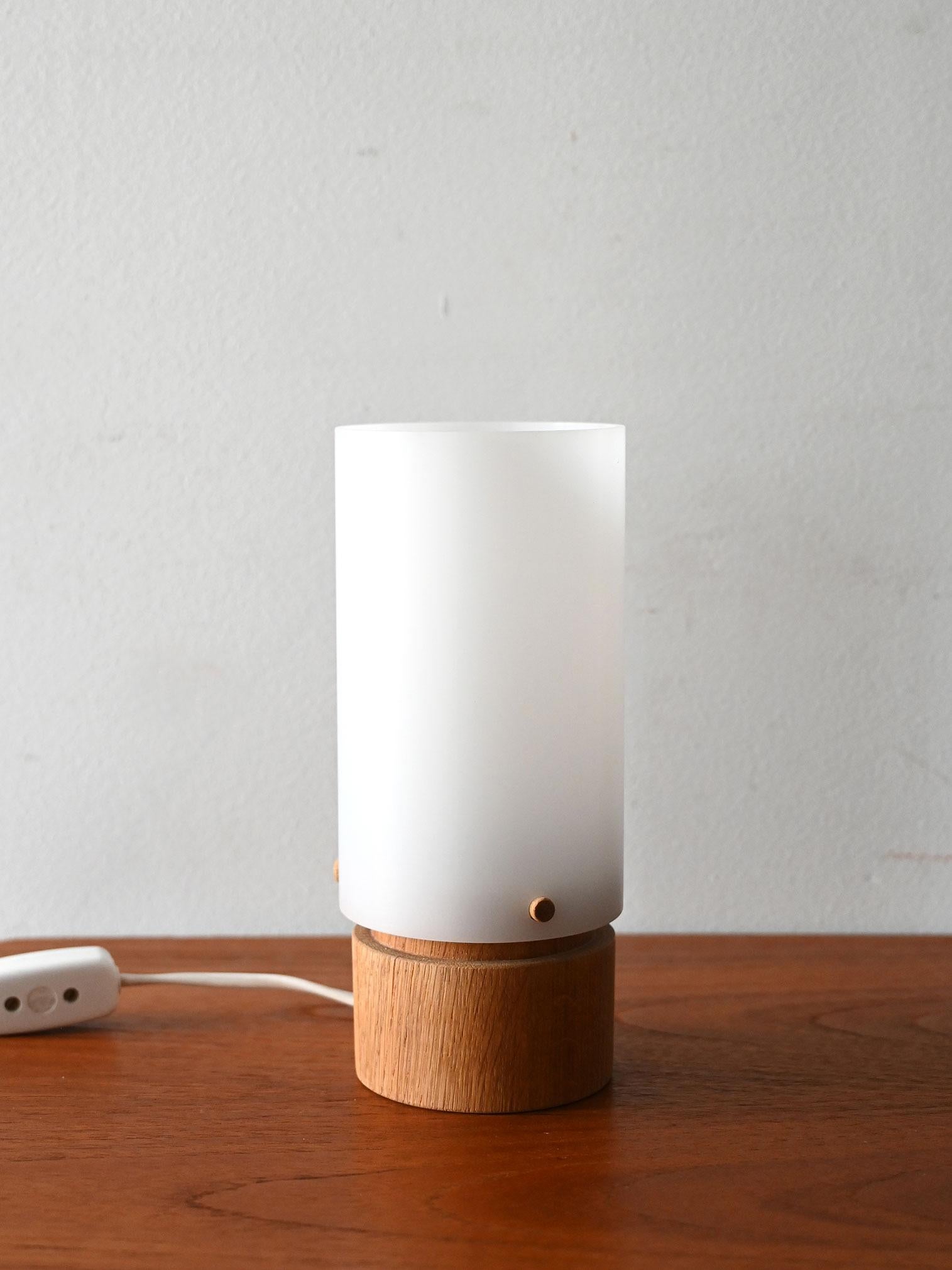 Lampada da tavolo in rovere e plastica bianca opaca, disegnata da Uno & Östen Kristiansson per Luxus negli anni ’60.

Lampada da tavolo disegnata da Uno & Östen Kristiansson per Luxus, Svezia, negli anni ’60. La base cilindrica è in rovere massello,