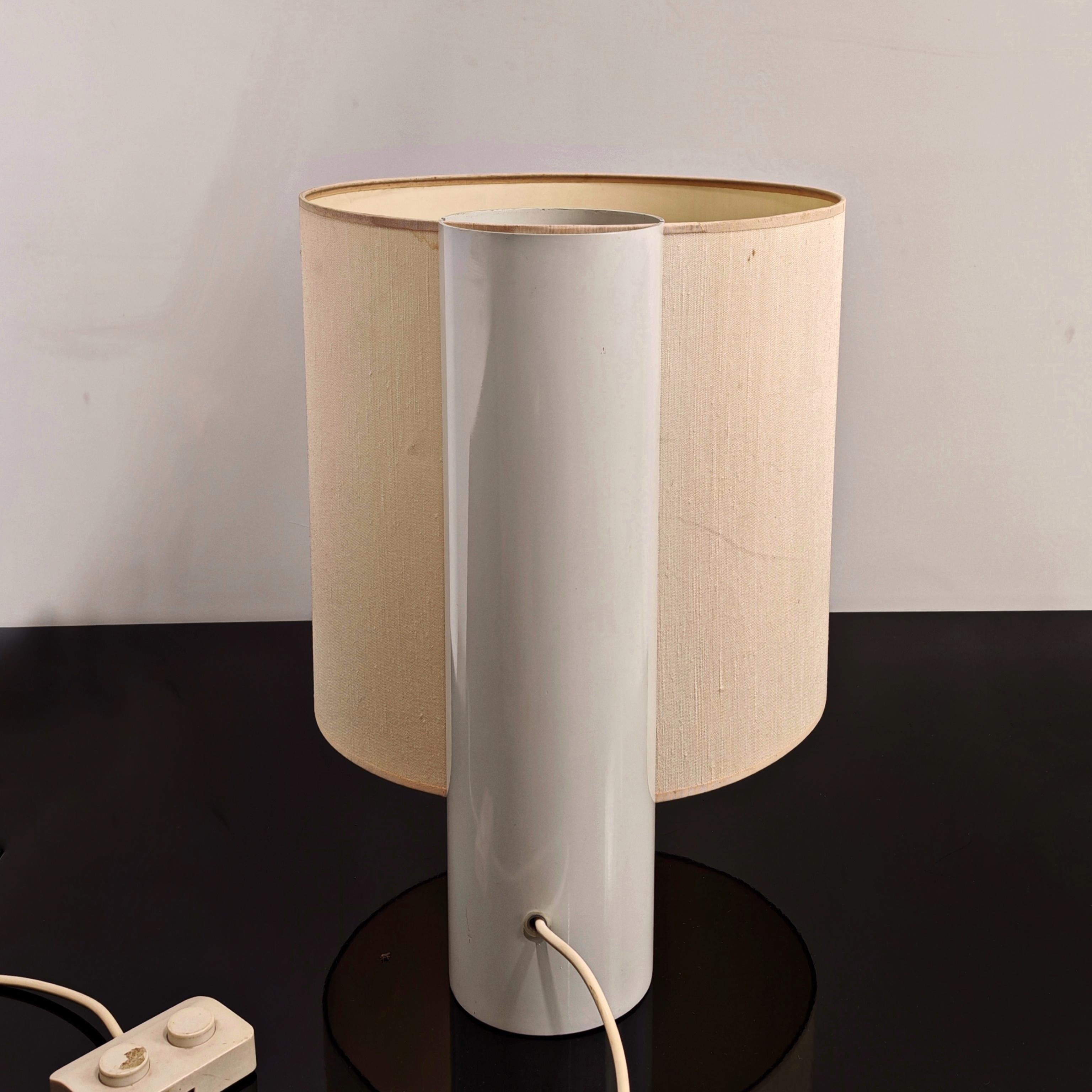 Table lamp mod. Fluette designed in the 1970s by Giuliana Gramigna for Quattrifolio. The lamp features a cylindrical white enameled aluminum frame and cylindrical plasticized fabric lampshade.
The lamp is dual ignition

 Condition: perfect