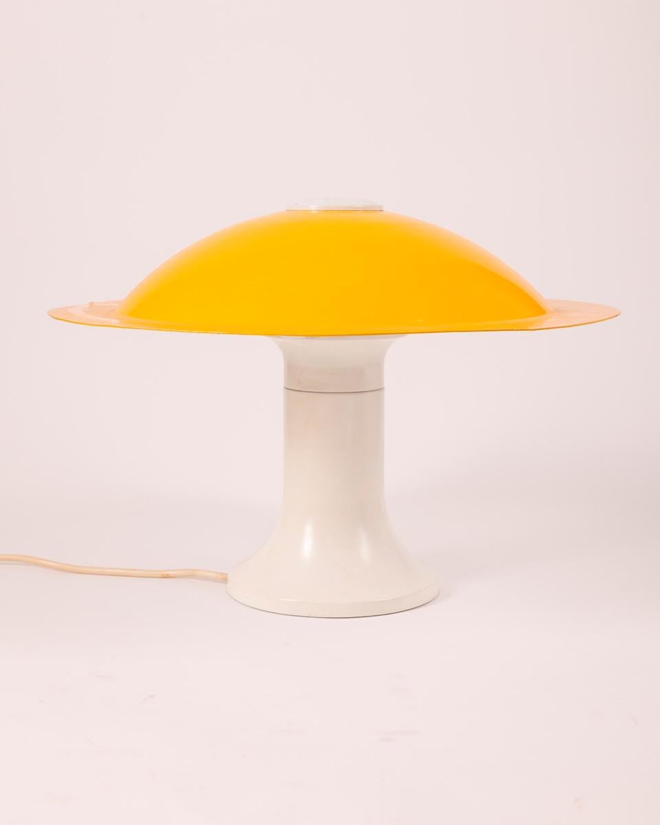 Three-light table lamp with white metal body and yellow shade, Martinelli design, 1970s.

CONDITION: In good condition, working, shows signs of wear given by time.

DIMENSIONS: Height 35 cm; Diameter 50 cm

MATERIALS: Metal

YEAR OF PRODUCTION: Anni