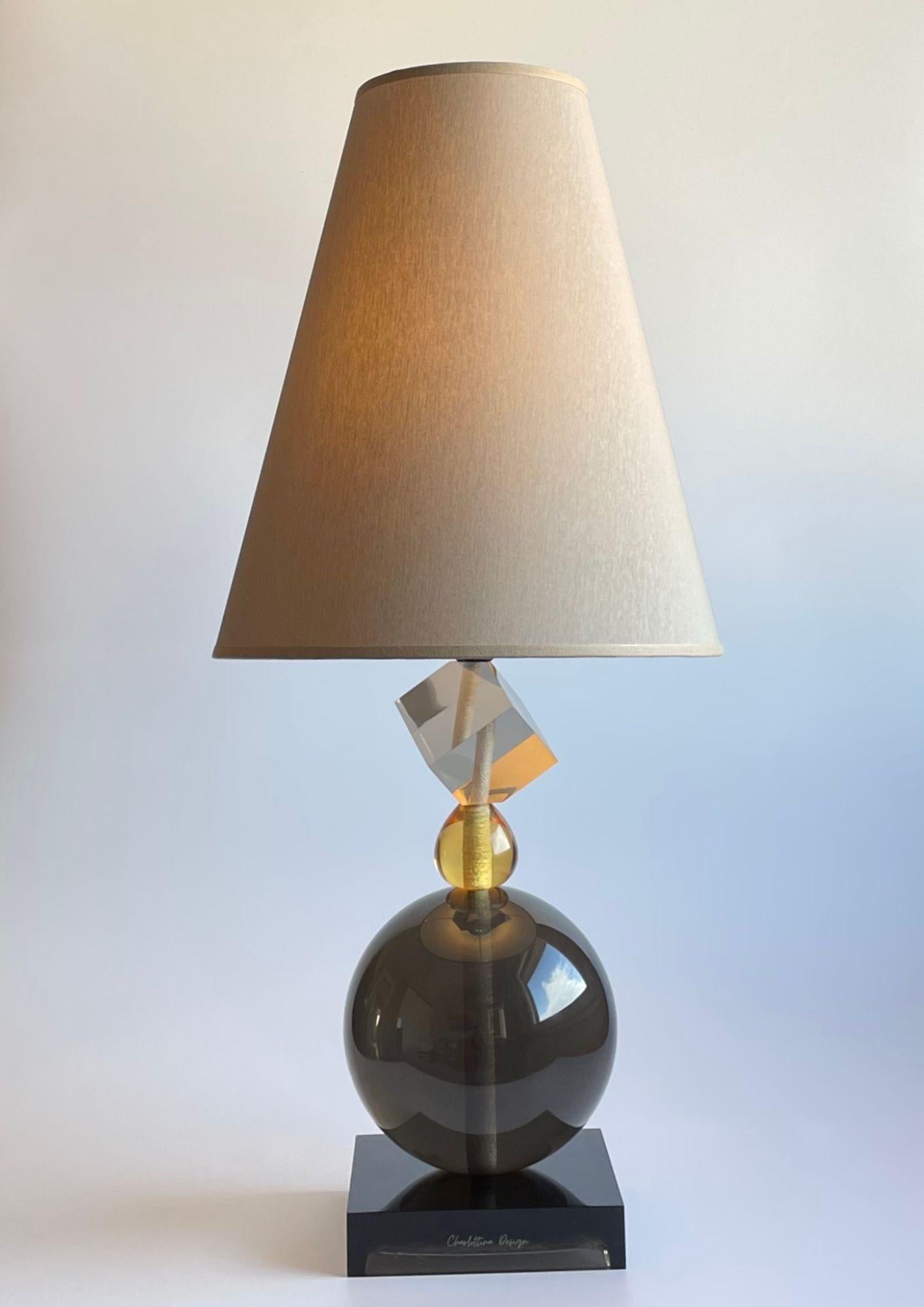 The Charlottina Design is a handcrafted resin table lamp with 100% Italian handmade cotton shade for design and manufacture.
Charlottina Design lamps are jewels of light that grace living rooms, bedrooms, offices. They fit casually, but always