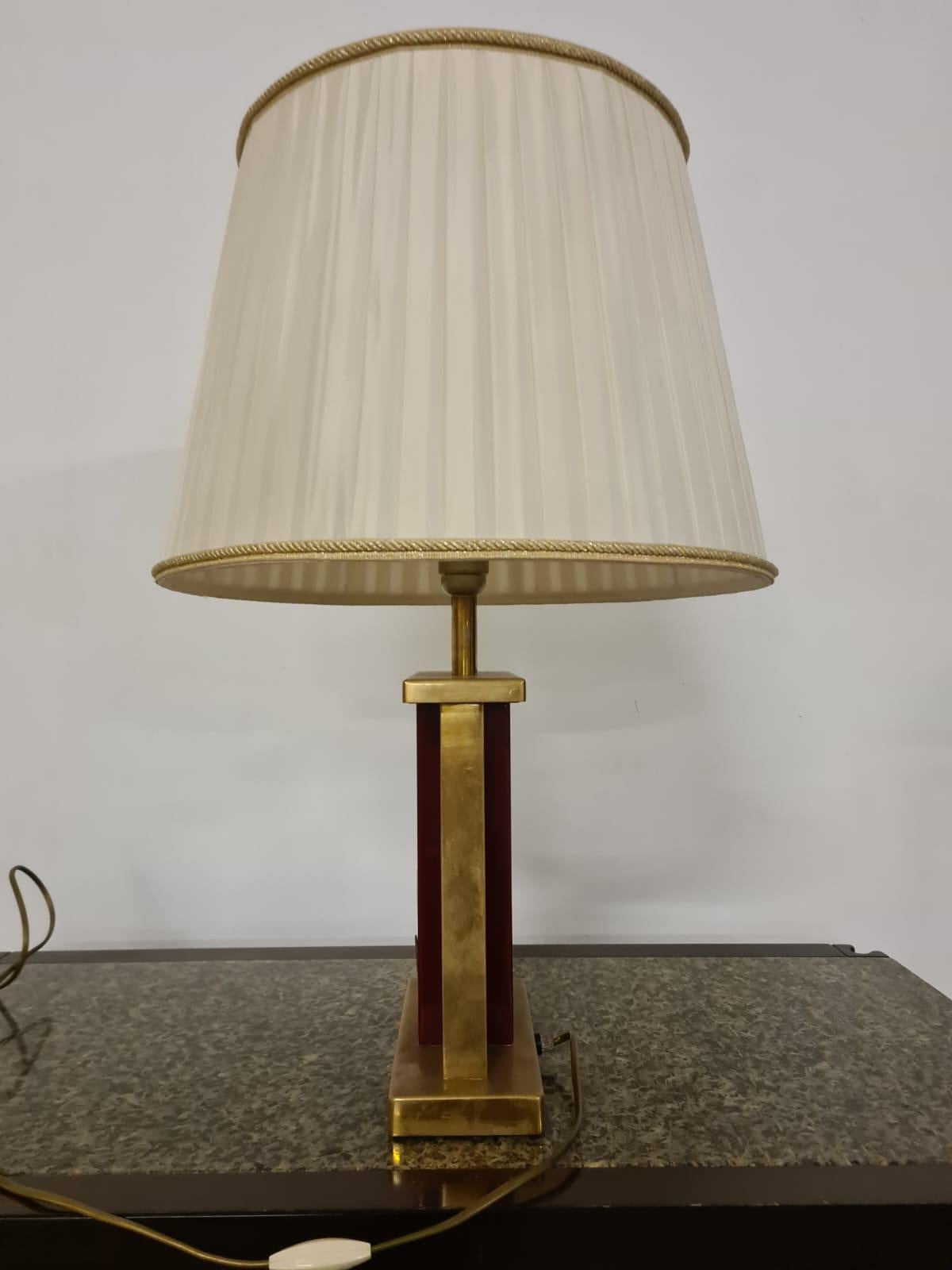 Hollywood Regency style table lamp.

Red lacquered and brass abat-jour with faunal decorations.

The lamp is in the Hollywood Regency style.

Late 1970s' period and probable French provenance.

Ideal for adding a touch of style and light to your