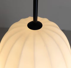 White glass table lamp with black metal base in mid-century 1960s style