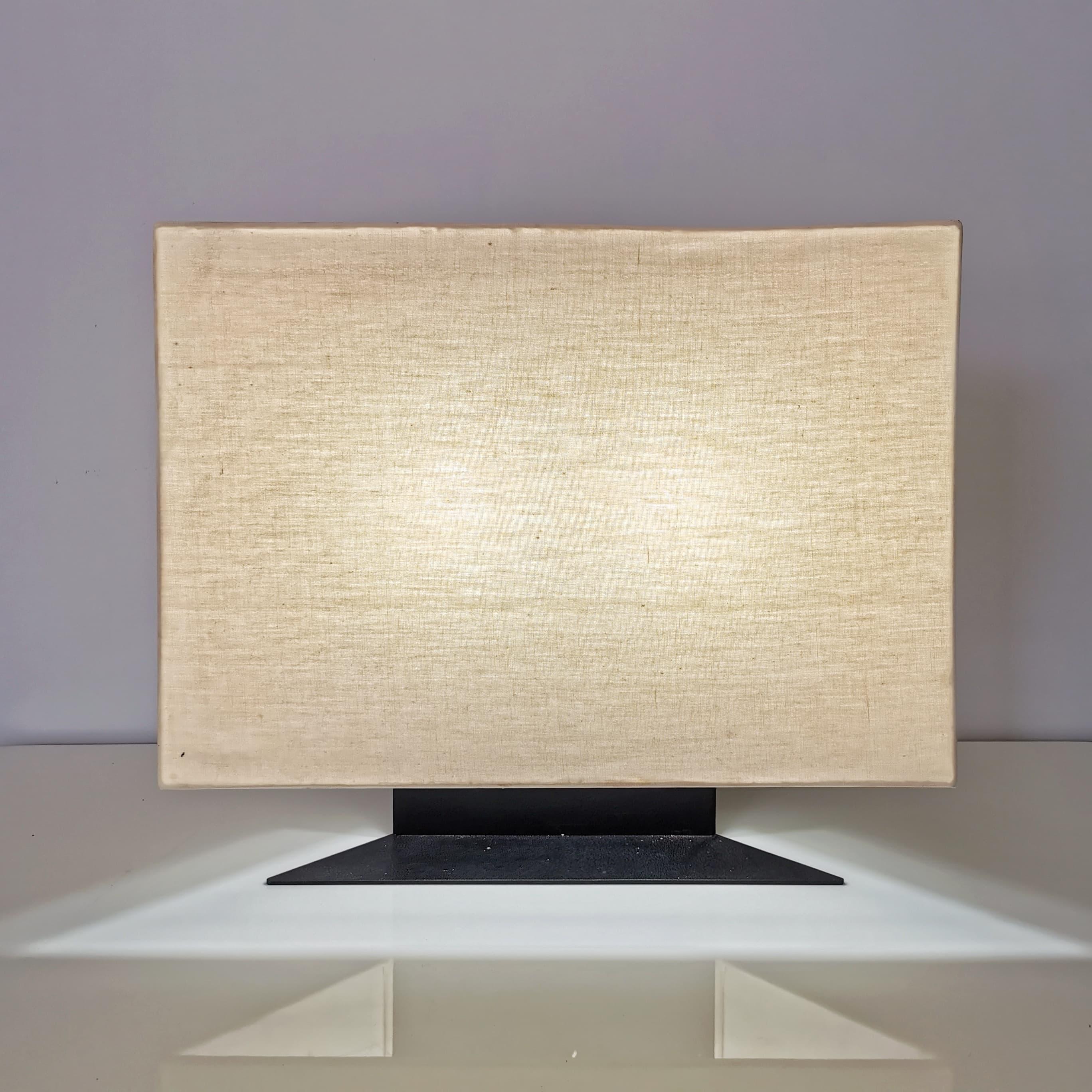 Particolare lampada da tavolo modello Accademia disegnata nel 1978 da Cini Boeri per Artemide. 
La Lampada è a sezione triangolare con una struttura in metallo  e un ampio diffusore in tessuto. 
La Lampada è in ottime condizioni generali con normali