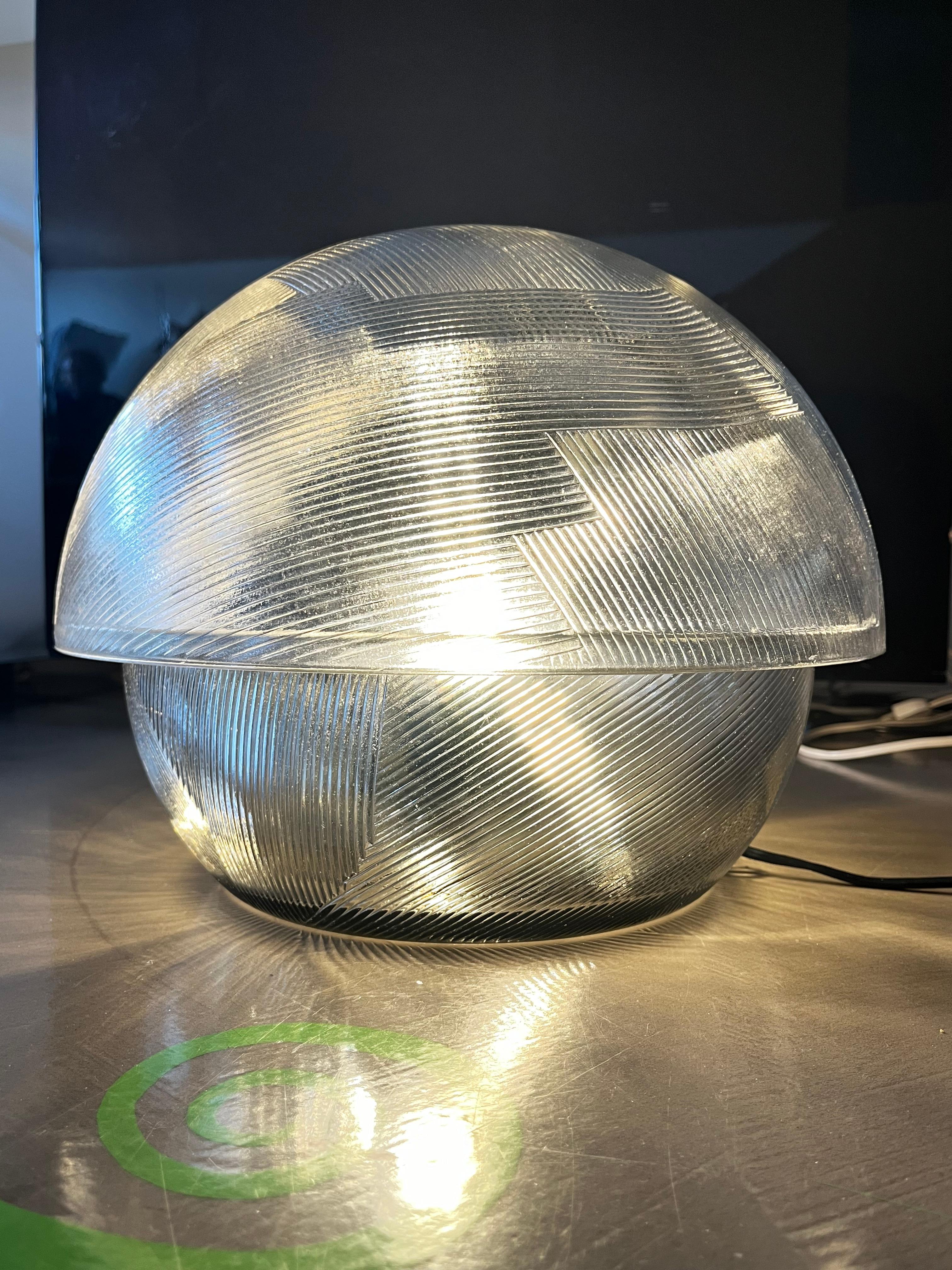 Lámpara de sobremesa de cristal trabajado, modelo Kyoto,  diseñado por Sergio Asti para Arnolfo di Cambio. La lámpara puede datarse en torno a 1970.

El cristal trabajado hace que el efecto de esta lámpara sea mágico. La lámpara tiene un peso