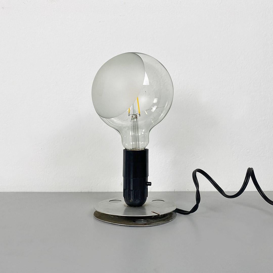 Lampadina model table or bedside lamp, with aluminum base, composed of two parallel discs, between which the electric cable is wound. In the central part there is its original lamp holder of the time, in good condition, while the bulbs are modern,