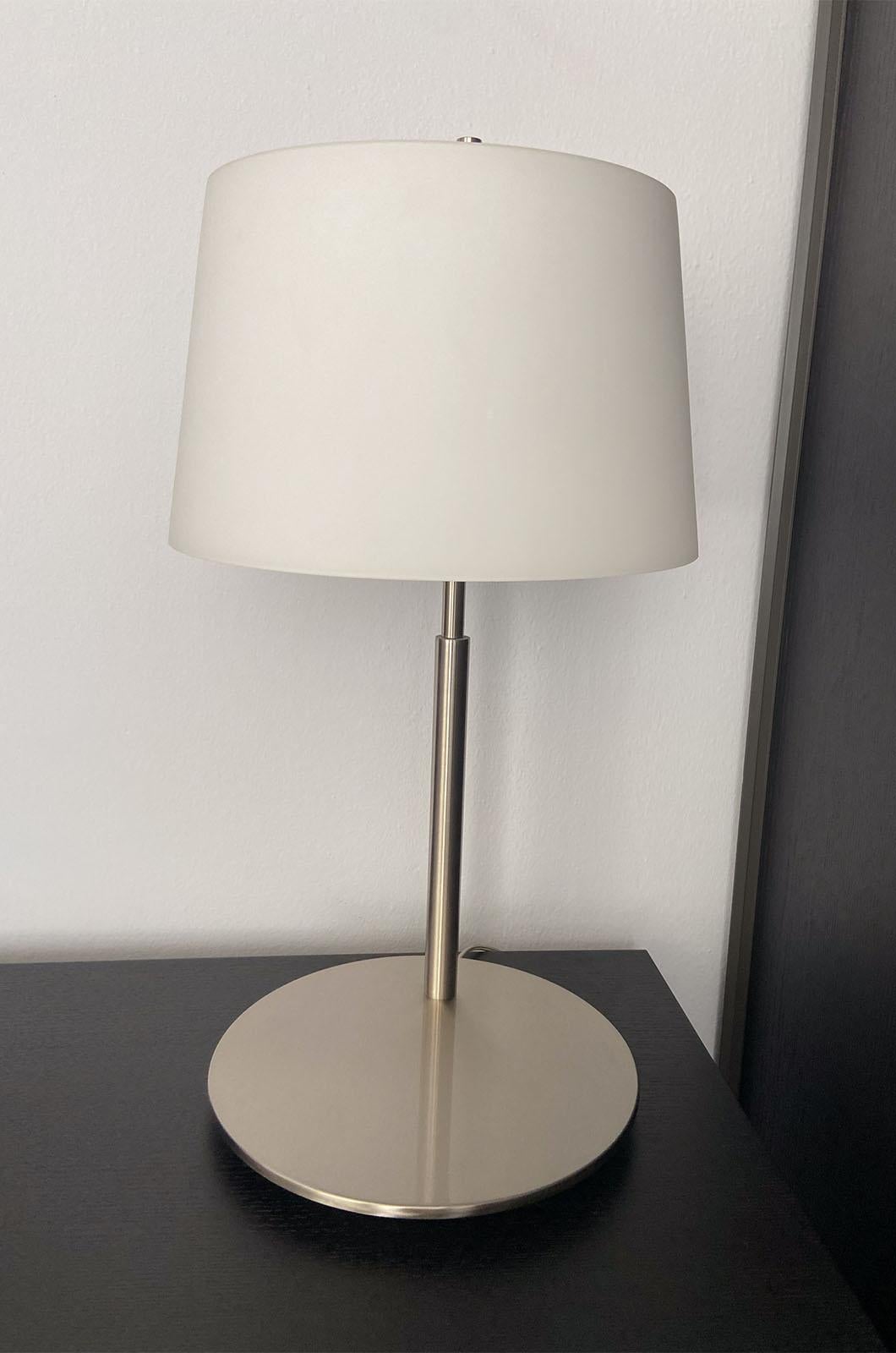 Lámpara de sobremesa con regulador de intensidad, diseñada por Studio Beretta Associati para Fontana Arte en 2004. Lámpara de líneas clásicas y elegantes, caracterizada por un difusor de cristal blanco opalino soplado y satinado que descansa sobre
