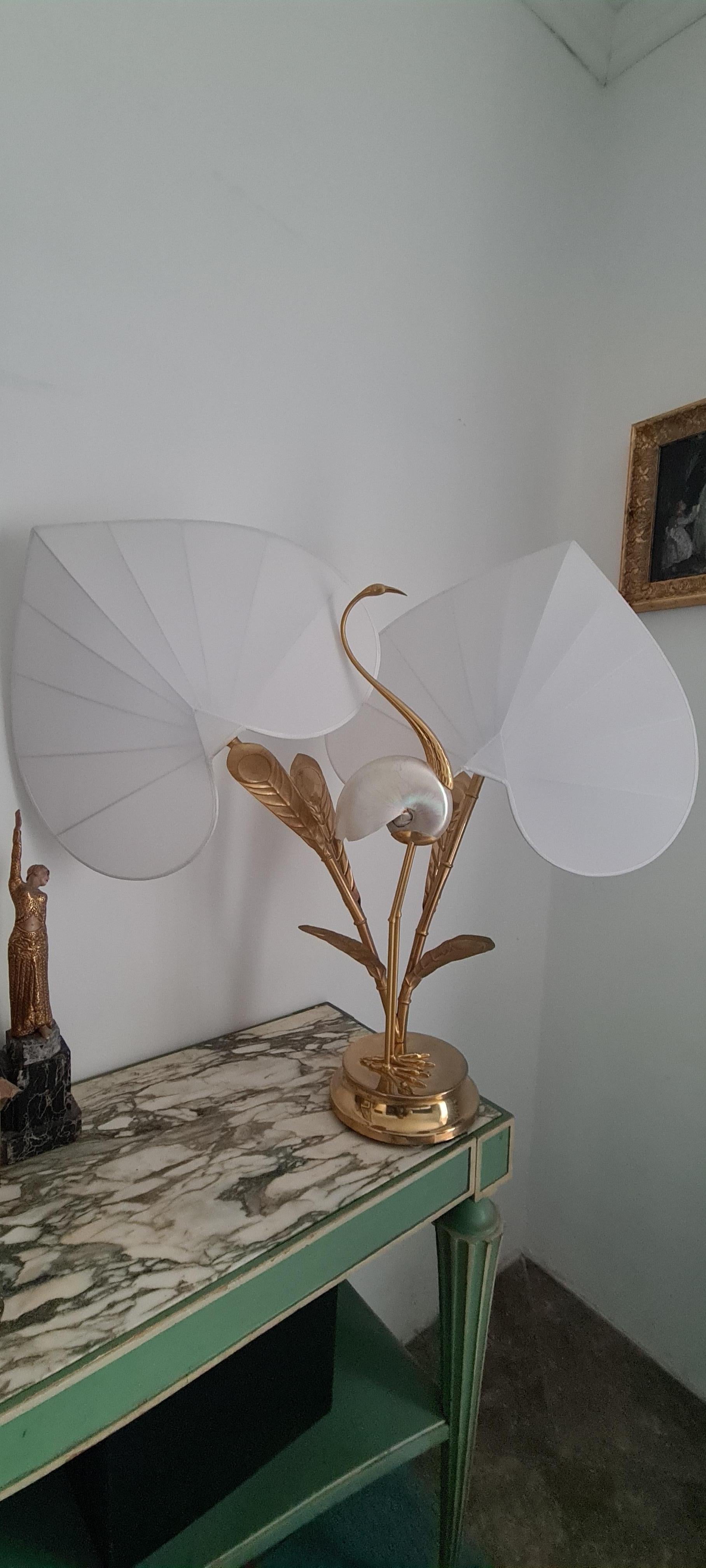 Antonio Pavia Lamp.

Table lamp by designer Antonio Pavia.

Lamp with brass base, brass bamboo-shaped stem and brass leaves, central heron-shaped statue made of brass and shell  of Nautilus in mother-of-pearl.

The hats of the two points of light