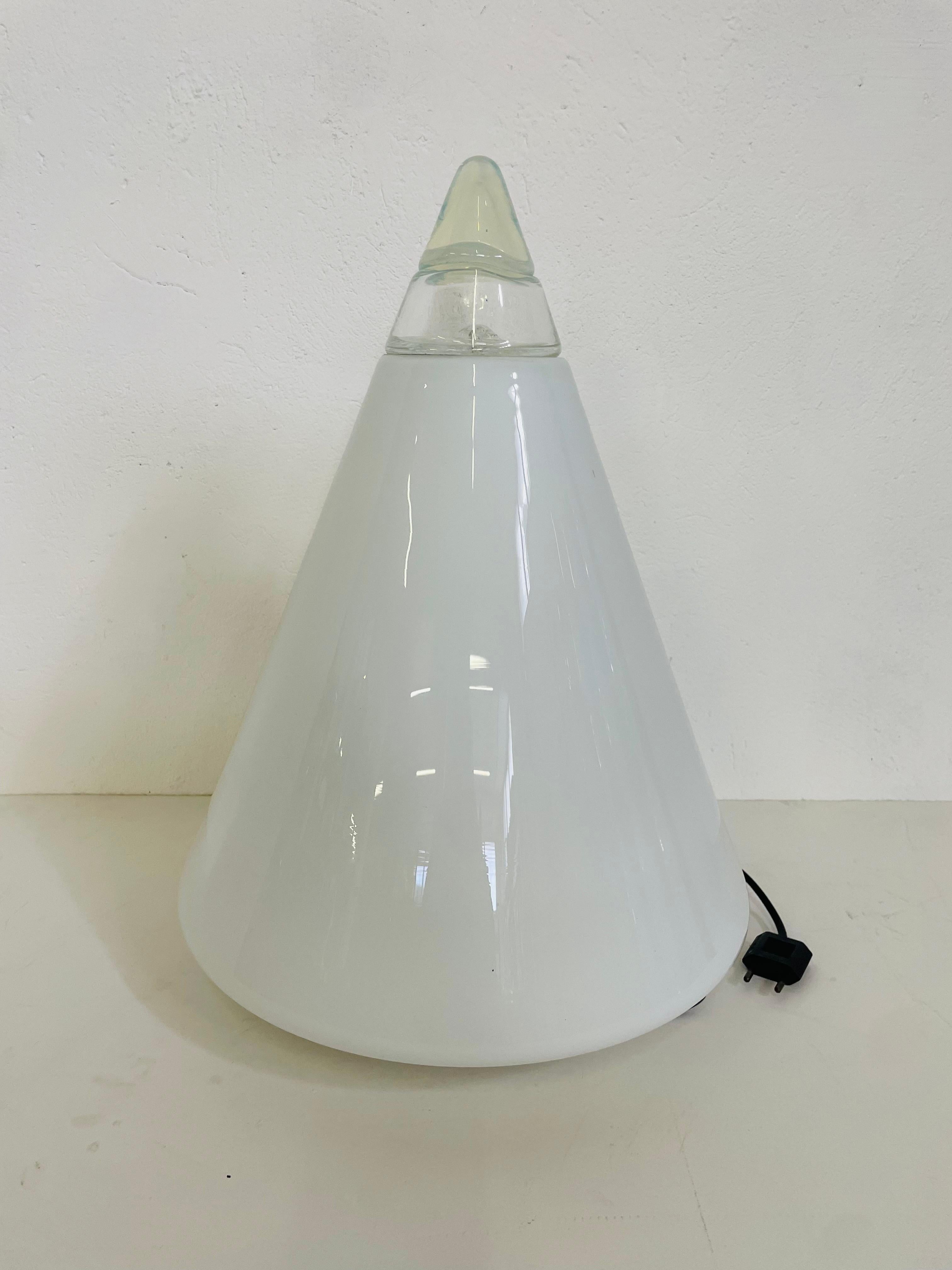 Rio model table lamp with a round base made of opaline white Murano glass.
The structure is conical, the lamp tip is made of transparent vtero.
Round white metal base, where we can be found under the production mark. It is prodaat by Leucos in the