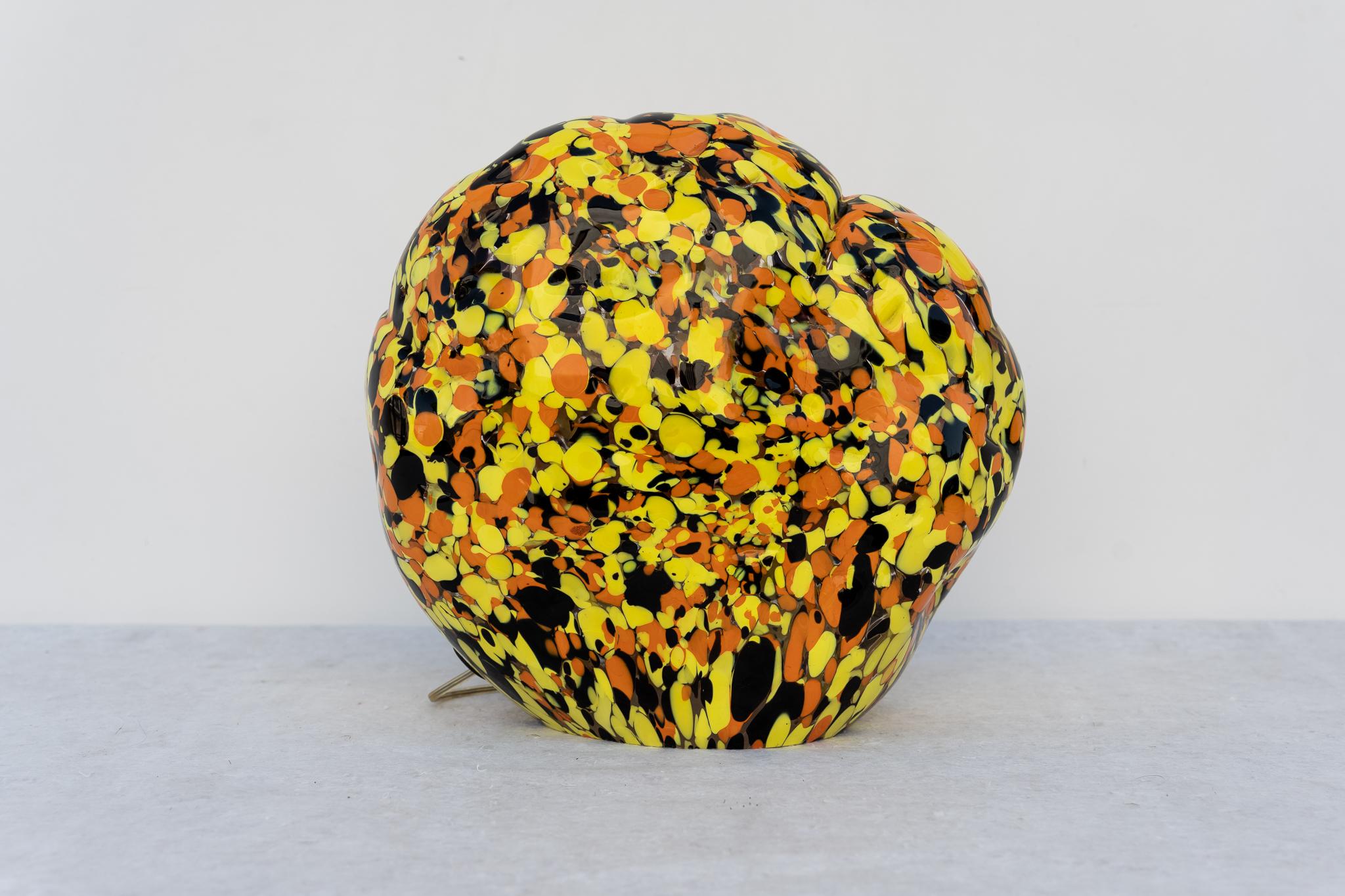 Lampe de table Sasso par Mimmo Rotella, Venini, années 2000, Made in Italy.
Sculpture lumineuse de l design inspirée par des formes et des motifs naturels et vivants. Le verre sur les murs est souvent dans les tons orange, jaune et noir. Sa forme