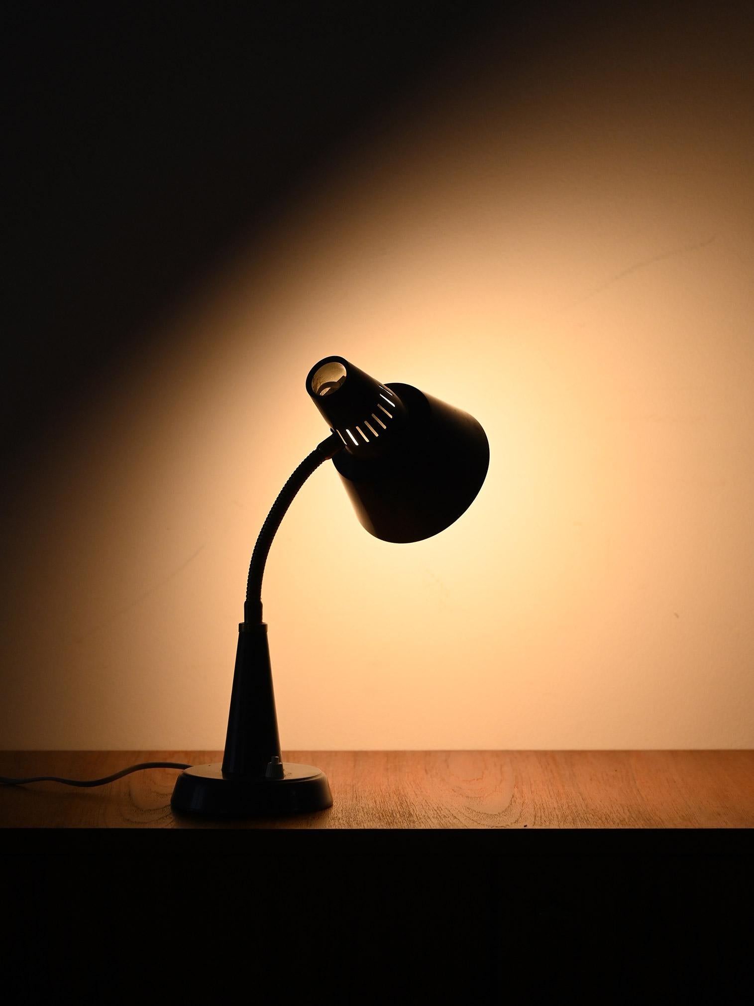 Vintage Scandinavian table lamp produced by Gemi, made of painted metal with brass details and flexible arm. Functional and essential design.

Vintage Scandinavian table lamp, made by Gemi with a painted metal base and shade and brass details. The