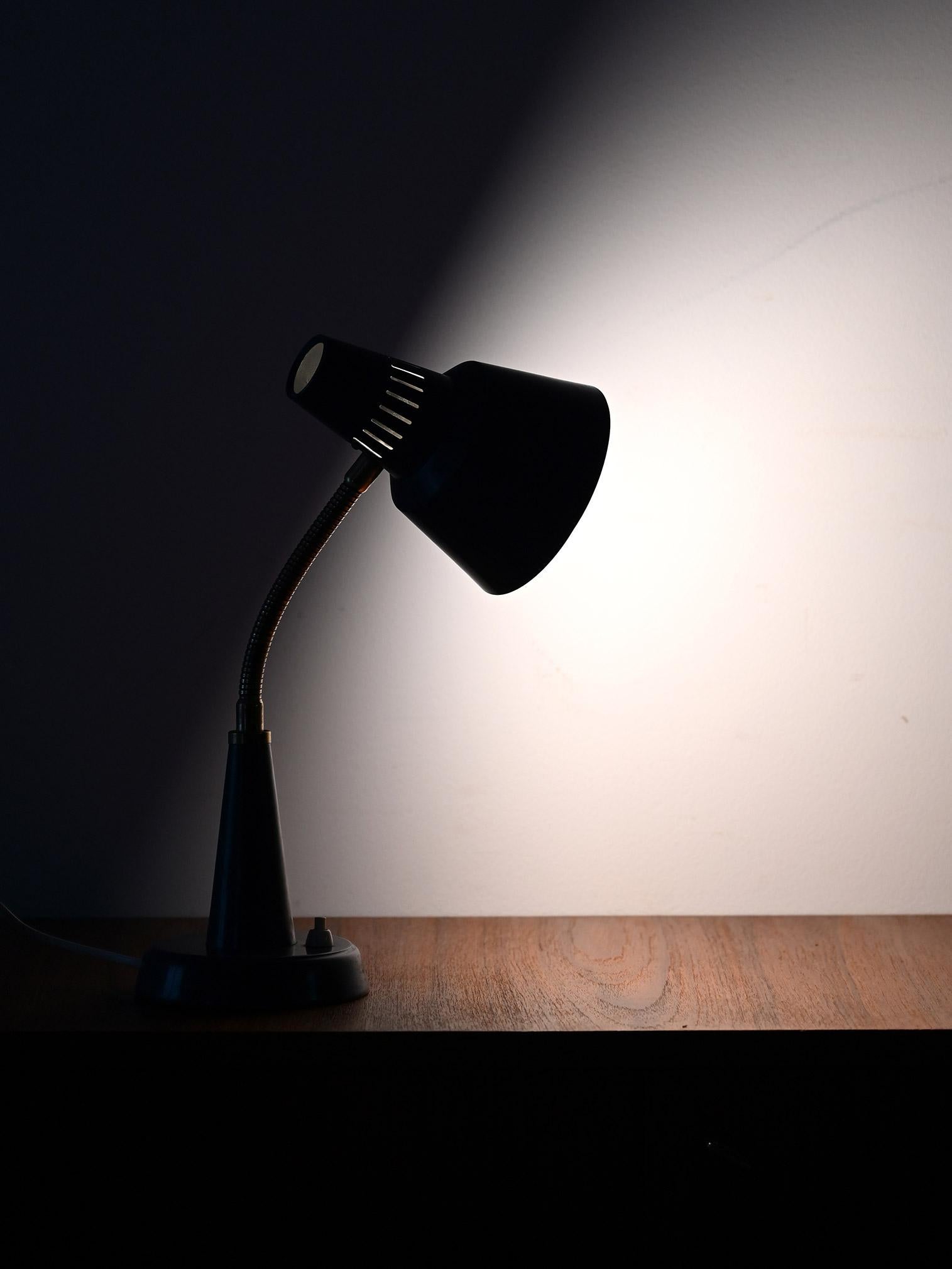 Vintage Scandinavian table lamp produced by Gemi, made of painted metal with brass details and flexible arm. Functional and essential design.

Vintage Scandinavian table lamp, made by Gemi with a painted metal base and shade and brass details. The
