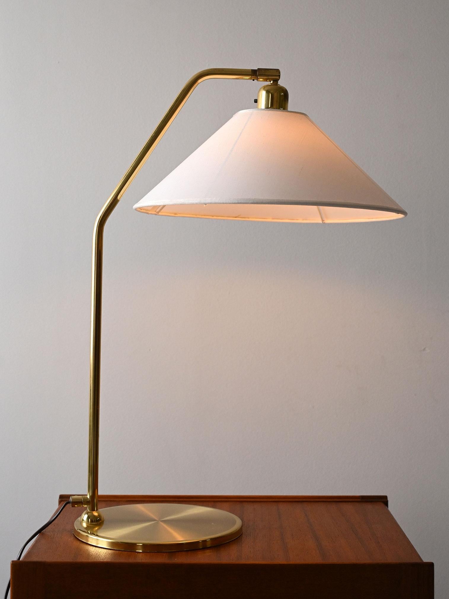 Lampada da tavolo vintage con struttura in ottone e paralume conico orientabile, nello stile di ASEA e Jakobsson.

Lampada da tavolo scandinava originale vintage risalente alla fine degli anni '50, realizzata con base in ottone lucido e paralume in