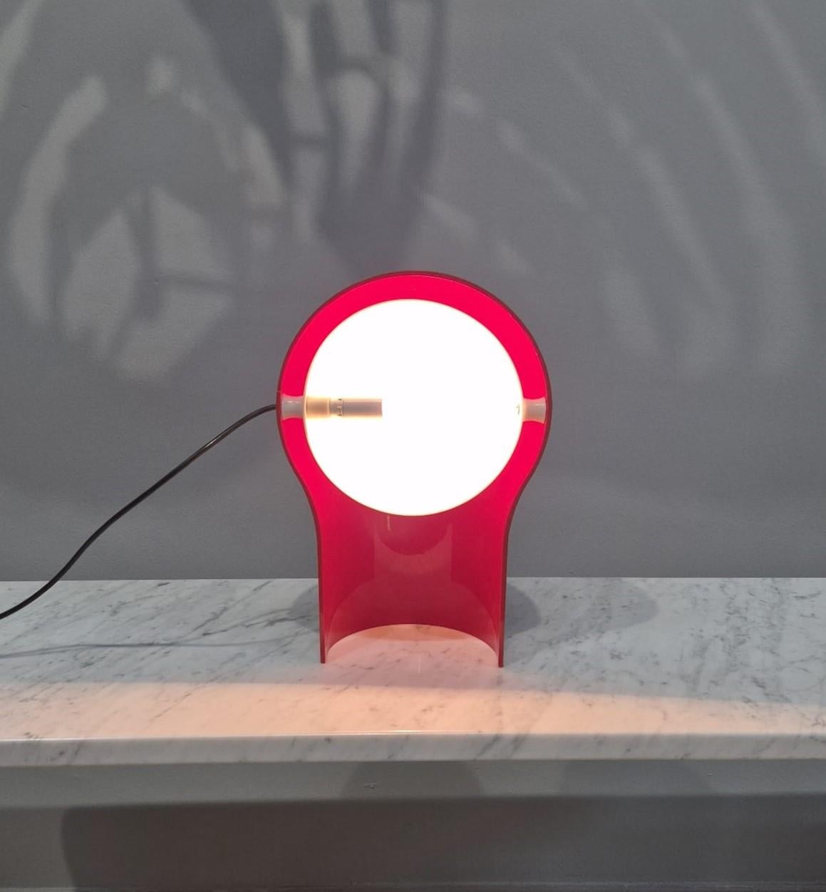 Lampe de table Telegono vintage, conçue par le célèbre Vico Magistretti pour Artemide en 1969. La base est réalisée en plastique rose et le paralume en plastique blanc.
Il paralume è, inoltre, orientabile e nasconde la lampadina donando una luce