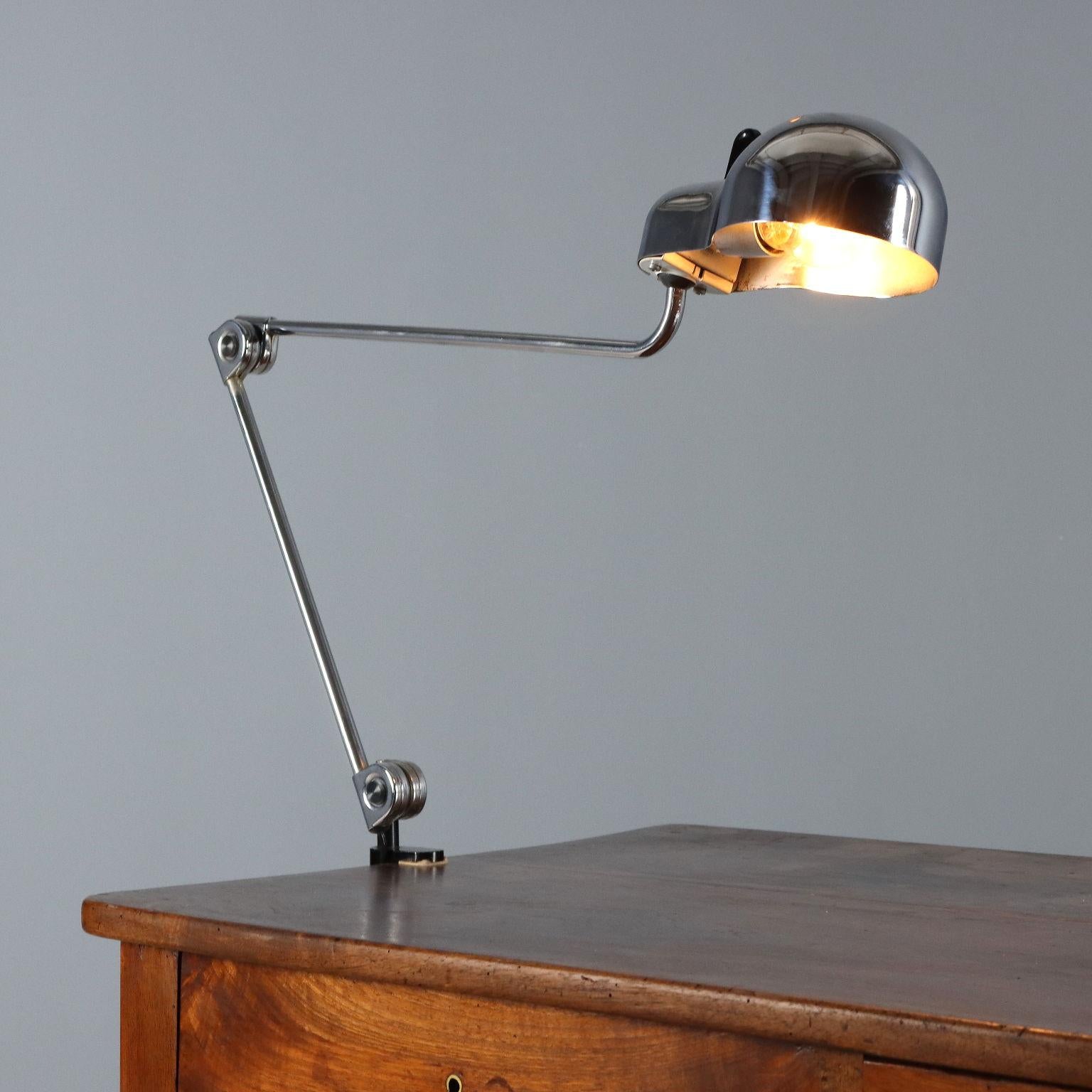 Chrome metal table lamp with jointed arms and clamp; production mark present.