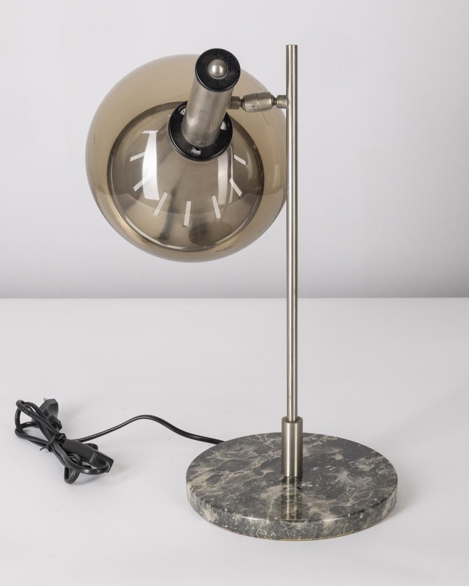Lámpara de sobremesa con base de mármol, cuerpo de metal cromado y pantalla de metacrilato gris, diseño Lamter Milano, años 50.

ESTADO: En buen estado de funcionamiento, puede mostrar ligeros signos de desgaste por el paso del tiempo.

DIMENSIONES: