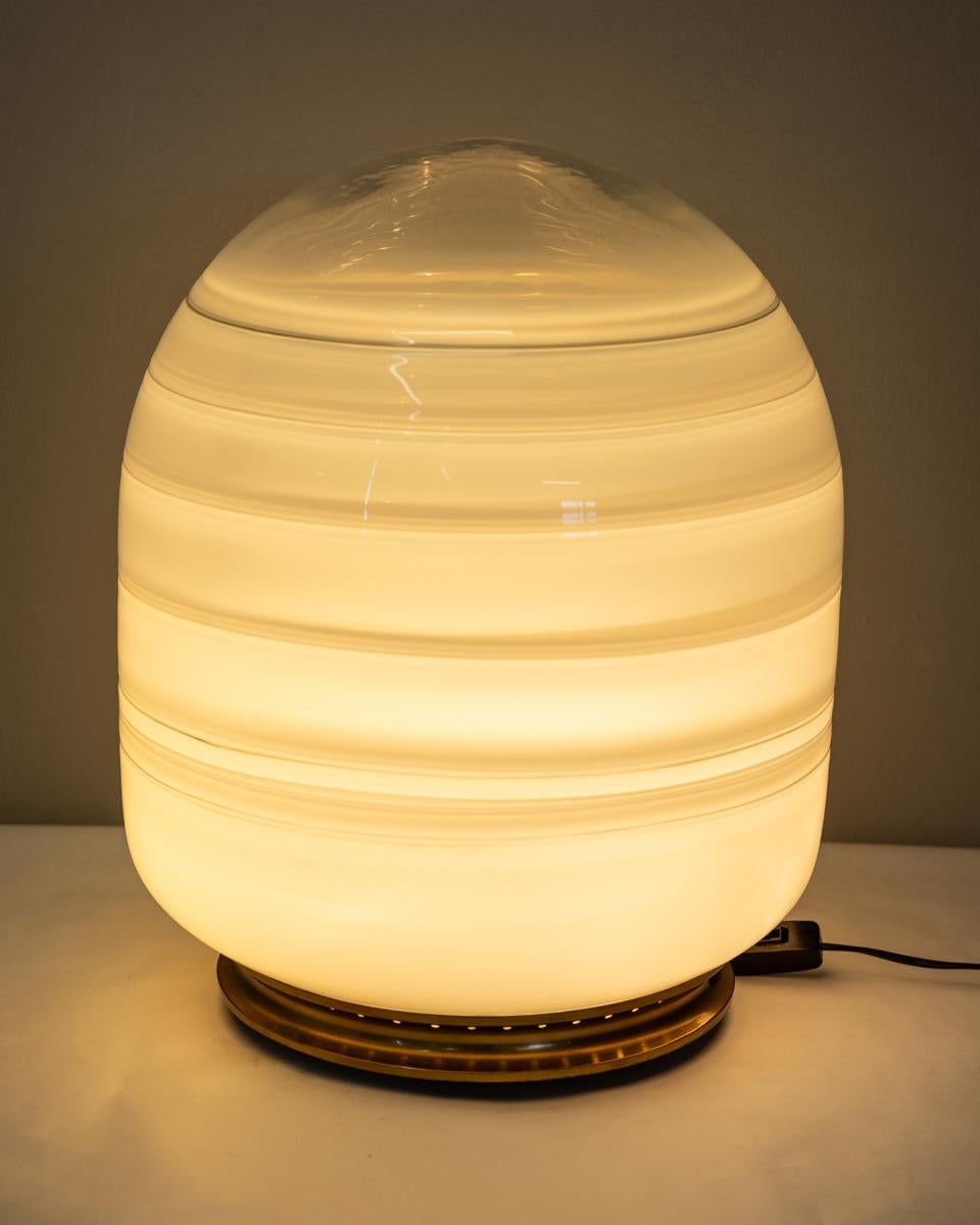Lampada da tavolo con base in ottone dorato e grande paralume in vetro di Murano, design Barbini, anni 70.

CONDIZIONI:
In buone condizioni, funzionante, può presentare segni d'usura dati dal tempo.

DIMENSIONI: 
Altezza 52 cm; Diametro 38