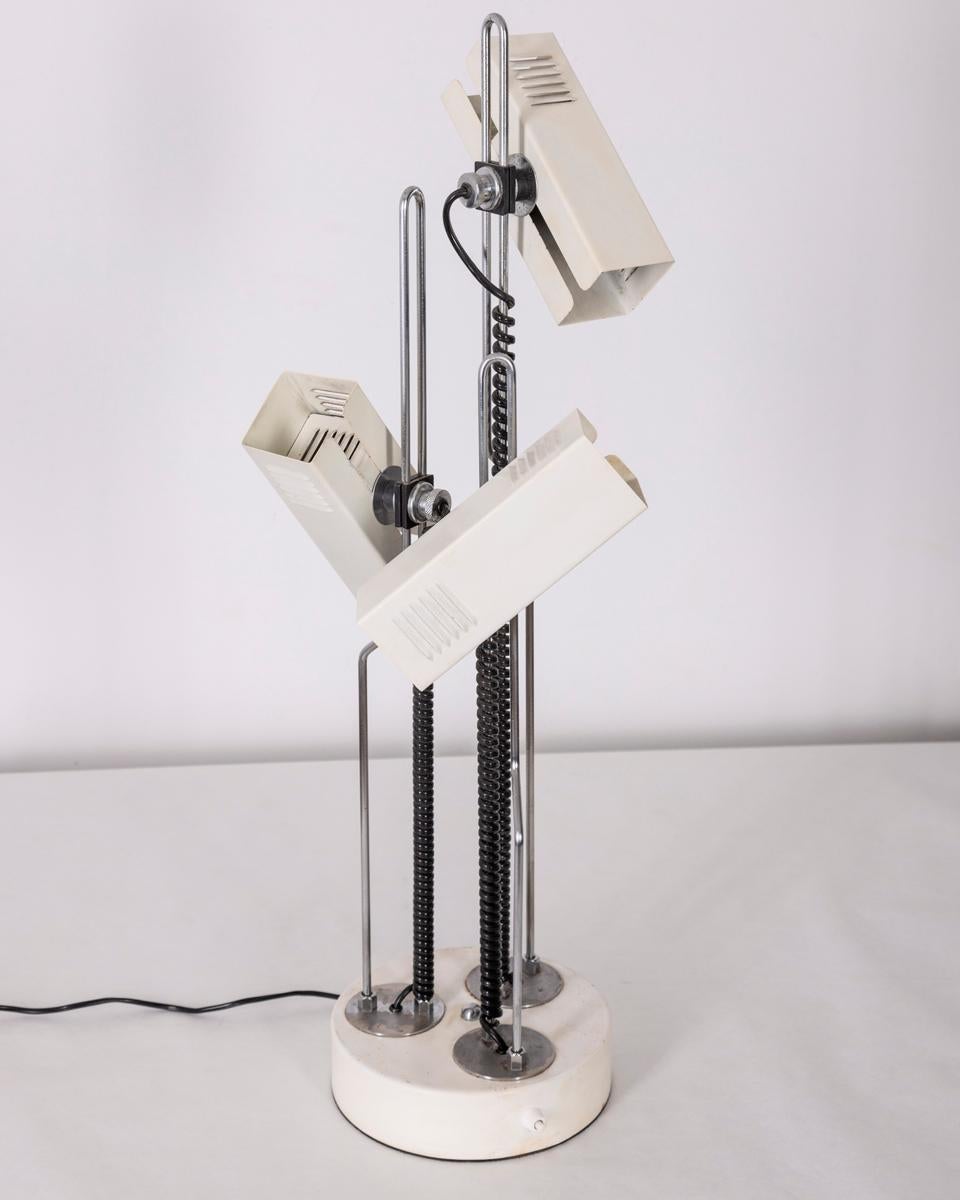 White and chrome metal table lamp with three adjustable lights, Italian design, 1970s.

CONDITION: In good condition, working, shows signs of wear given by time.

DIMENSIONS: Height 75 cm; Diameter 22 cm

MATERIALS: Metal

YEAR OF PRODUCTION: Anni 70