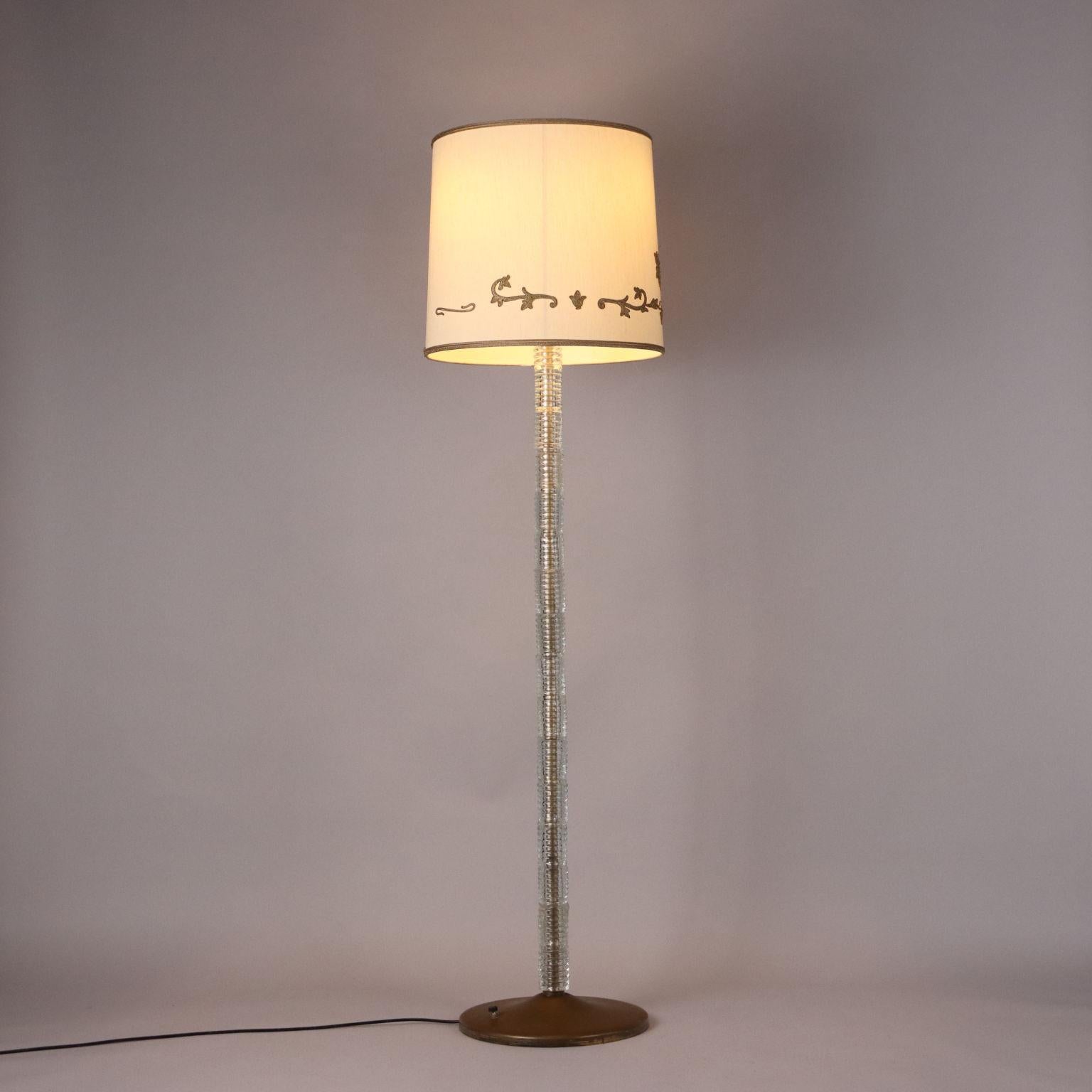 Floor lamp made of brass and blown glass, diffuser made of plasticized fabric. Good condition, has one glass break at the base, as pictured.