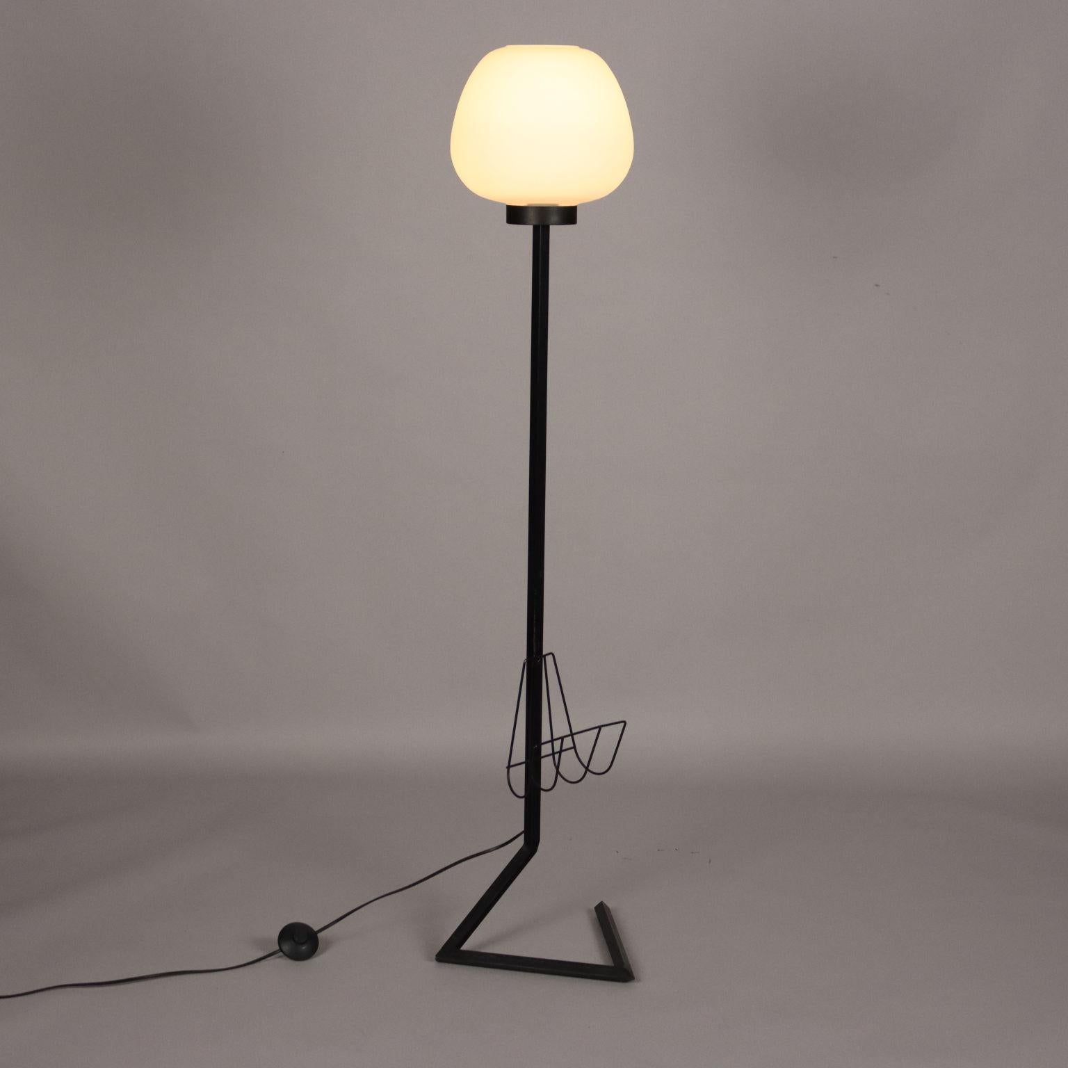 Floor lamp with magazine holder, made of enameled metal and the diffuser of opal glass. 