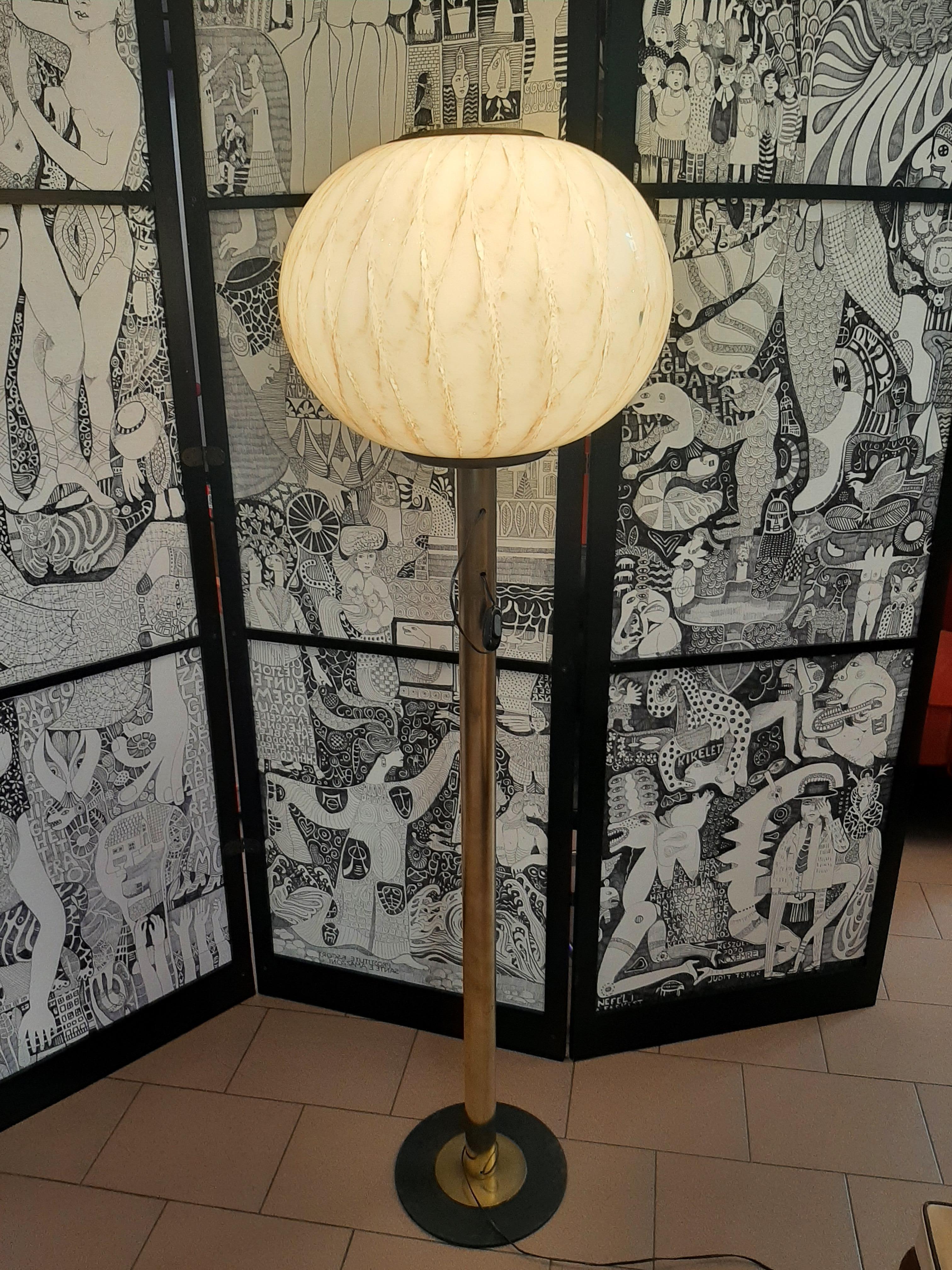 Lampada da terra in vetro di Murano e ottone.
Bellissima ed elegante lampada da terra degli anni '70. La parte superiore della lampada è in vetro Murano con venature dorate. Base in ottone e metallo. Perfettamente funzionante.