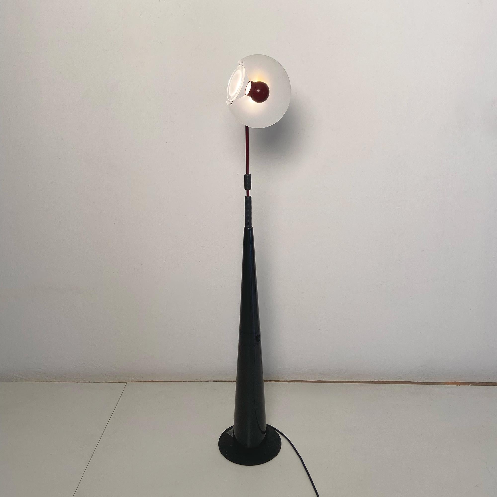Lampada da terra Club 1195 disegnata da Giuseppe Ramella nel 1983 e prodotta da Arteluce. Il prodotto è costituito da un basamento in ghisa e struttura in metallo laccato. Disco superiore in vetro sabbiato con faretto luminoso, che punta su un disco
