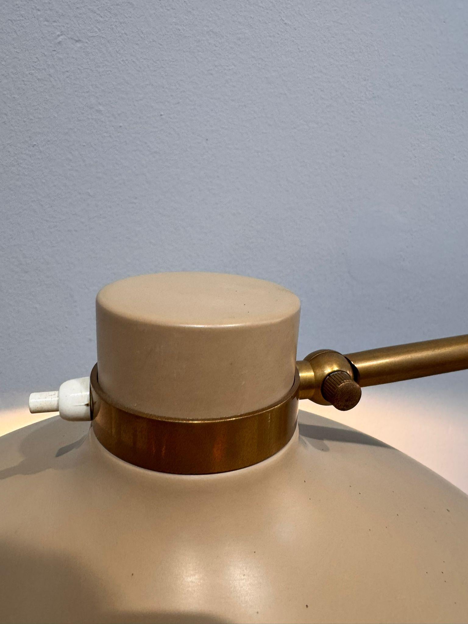 This floor lamp from the 1950s by Gio Ponti is a fine example of Italian modernist elegance, featuring a slender brass frame that lends lightness and dynamism, with an articulated, extendable arm that allows the diffuser to be oriented for versatile