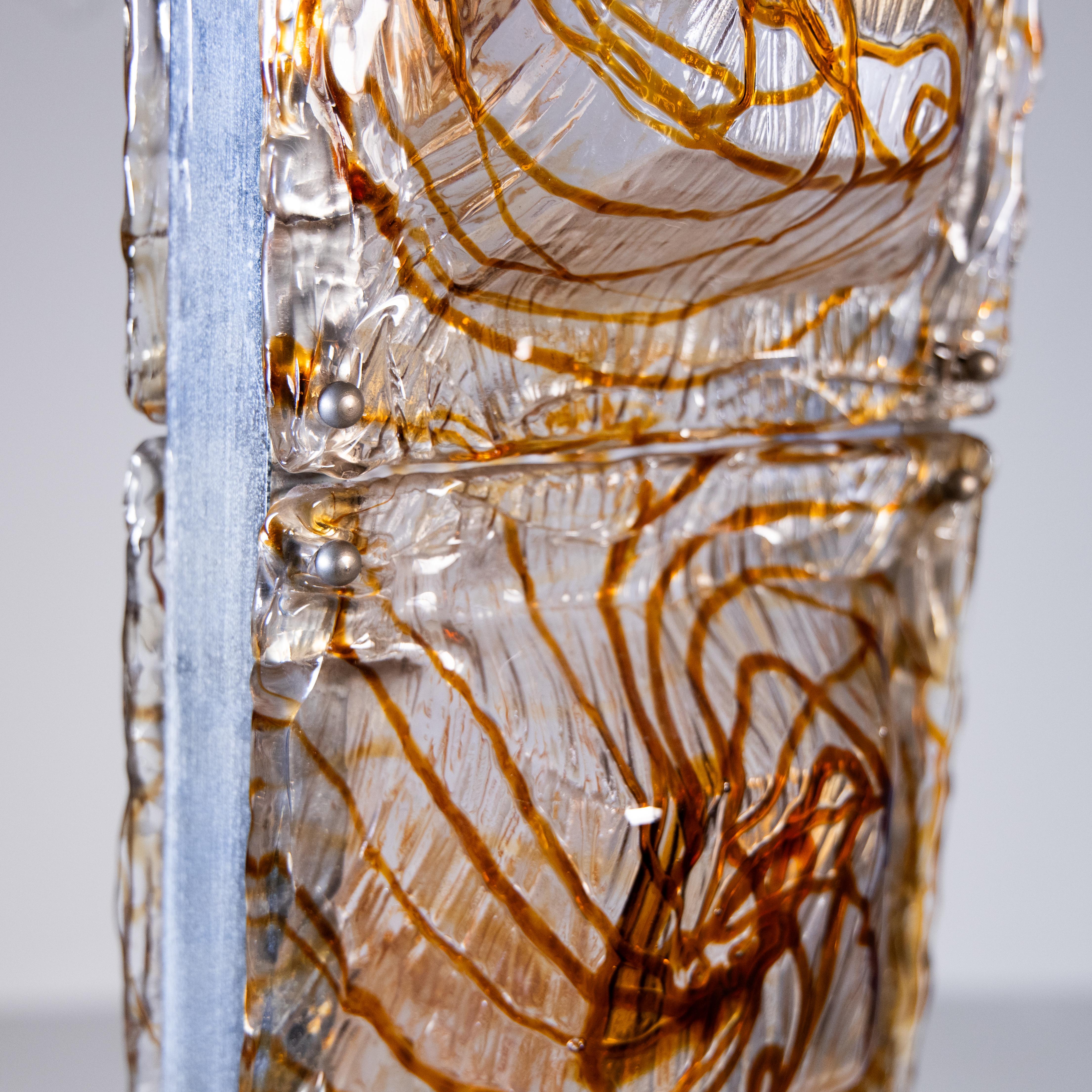 Floor lamp, 1970, featuring a decorative design typical of the period. The main structure is made of steel, with clean, modern lines that reflect the minimalist aesthetic of the 1970s. The diffusers made of decorated Murano glass, known for its