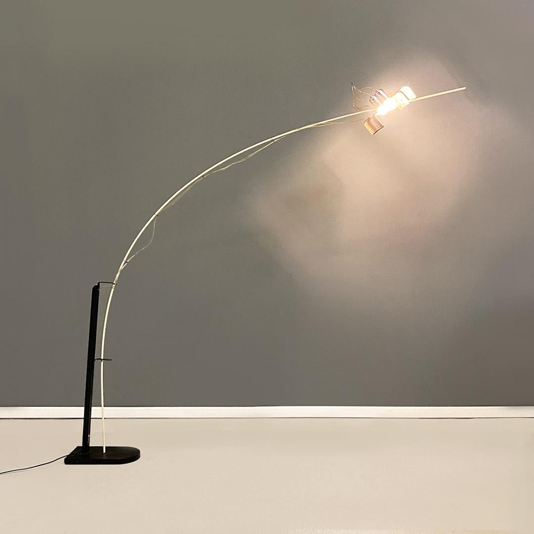 Floor lamp model L'Amo with a matt black metal frame with a rough finish, flat base with a small hole placed in the center from which a white elastic rod starts, which, through a loop in the same structure, hangs forward to support the perforated
