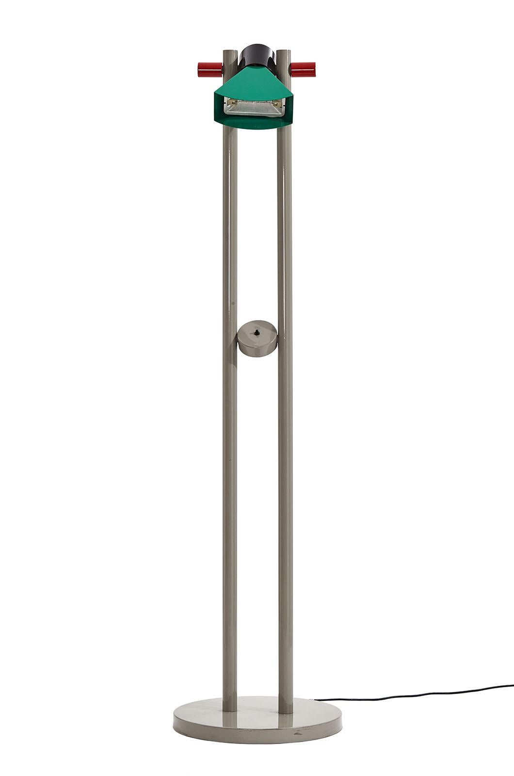 Designed by Aldo Cibic in 1983 for Memphis. This floor lamp consists of two tubes attached to a circular base, with the switch and main light source positioned in the center. The diffuser, which plays with volume and color, is 