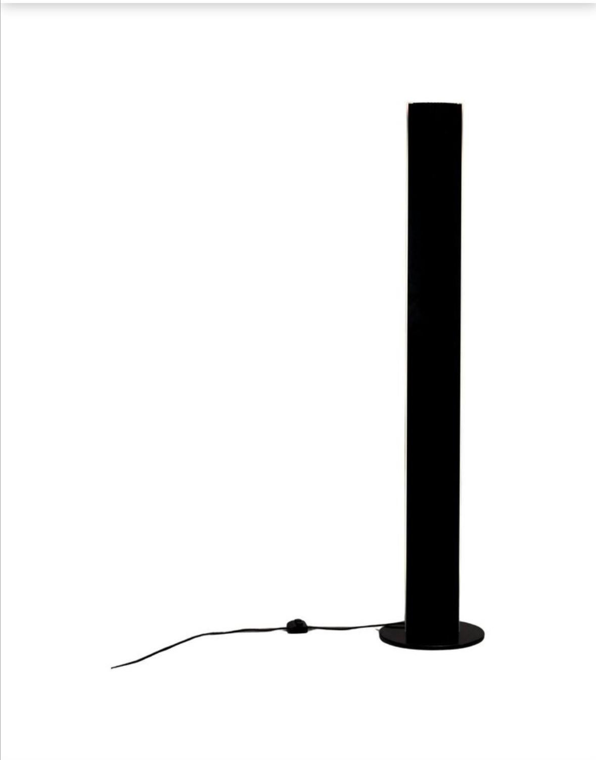 The Tronconi floor lamp Manhattan model, dating from the 1970s, features a minimalist and elegant design typical of that period. 
Design and Structure:
Clean and geometric lines: The lamp is characterized by its sleek, cylindrical shape with a