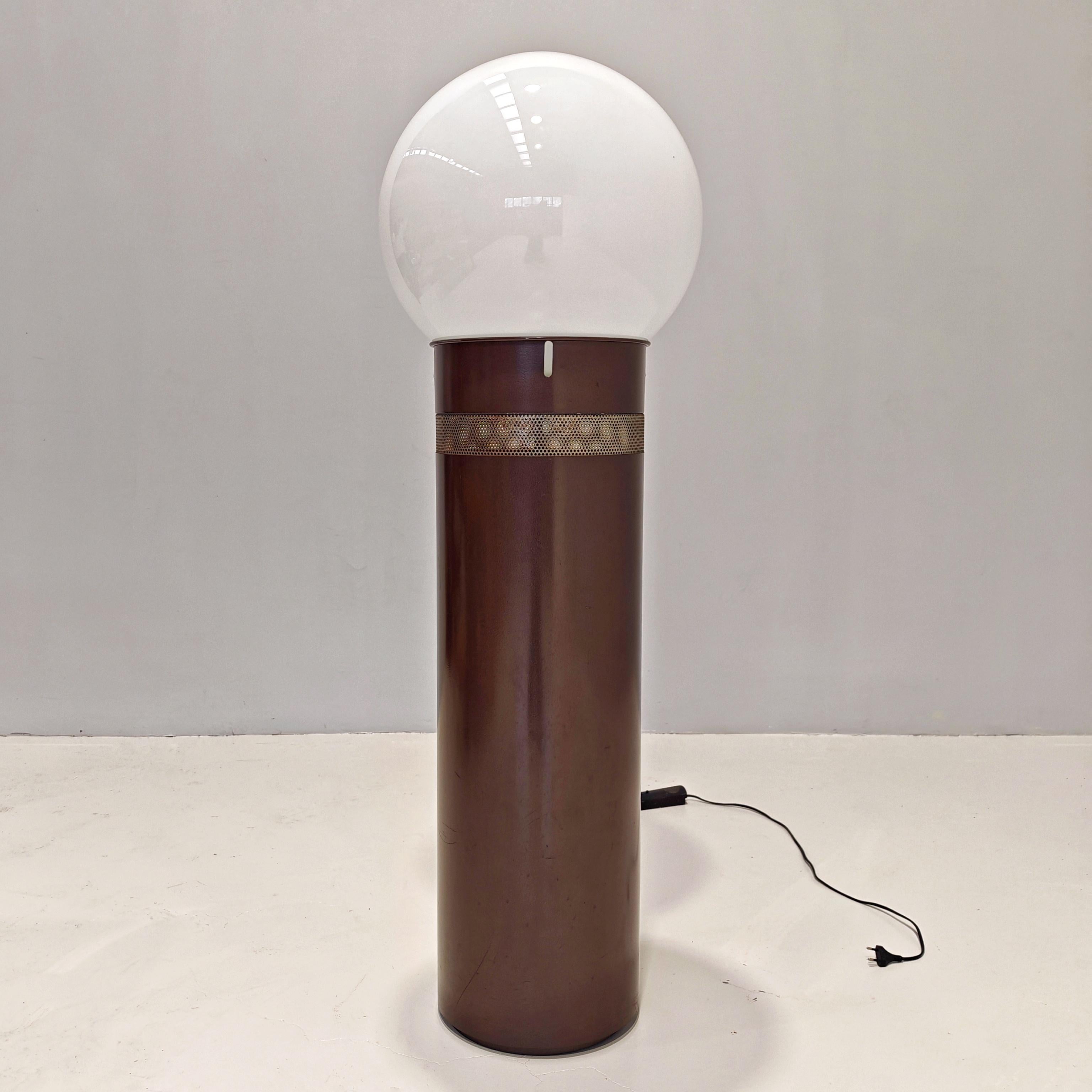 ampada piantana Oracolo Grande créé en 1969 par Gae Aulenti pour Artemide. Structure tubulaire en métal peint en brun avec bandeau en maille d'acier perforé et grand diffuseur sphérique en verre blanc. La lampe est gradable et comporte une ampoule