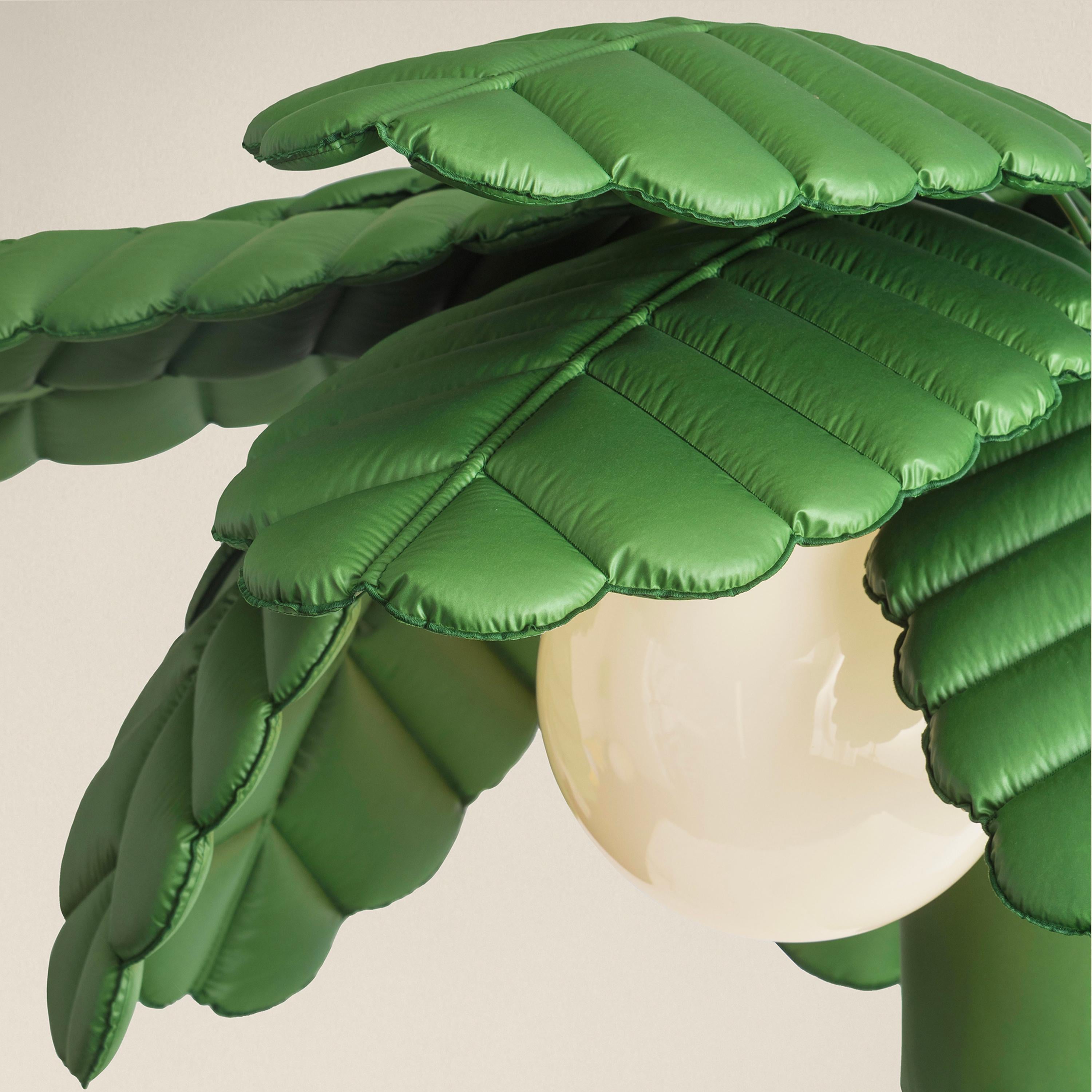 Caratterizzata da un design scultoreo e ironico, la lampada unisce estetica contemporanea e funzionalità. La struttura in metallo verniciato a polvere è rivestita in tessuto PL riciclato, che avvolge lo stelo centrale e si dirama in 12 foglie