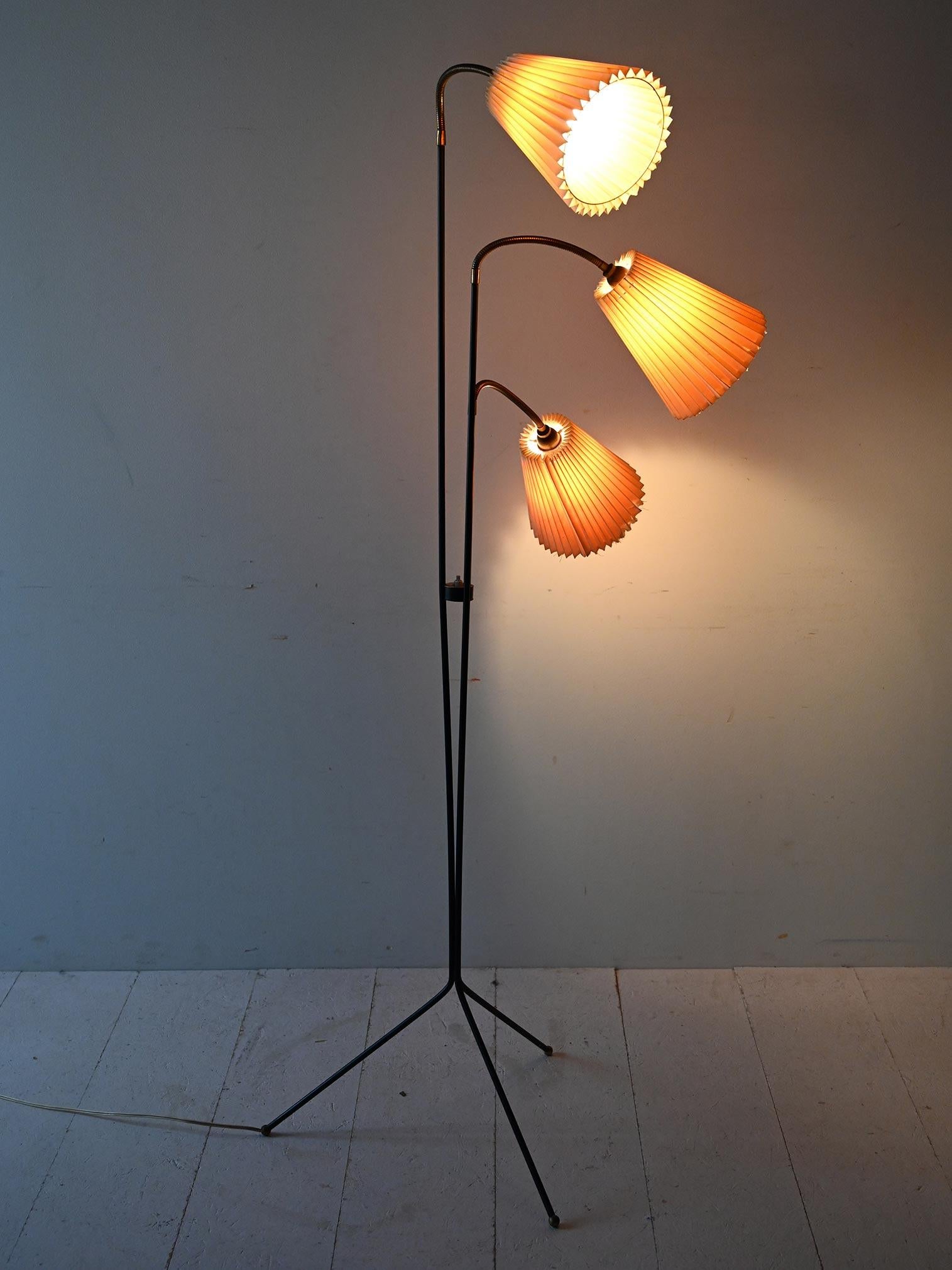 Scandinavian vintage lamp with metal frame and pleated fabric lampshades. The arms are adjustable.

Scandinavian 1950s design with a sleek black metal frame and three adjustable brass arms. The original rigid pleated fabric lampshades diffuse a