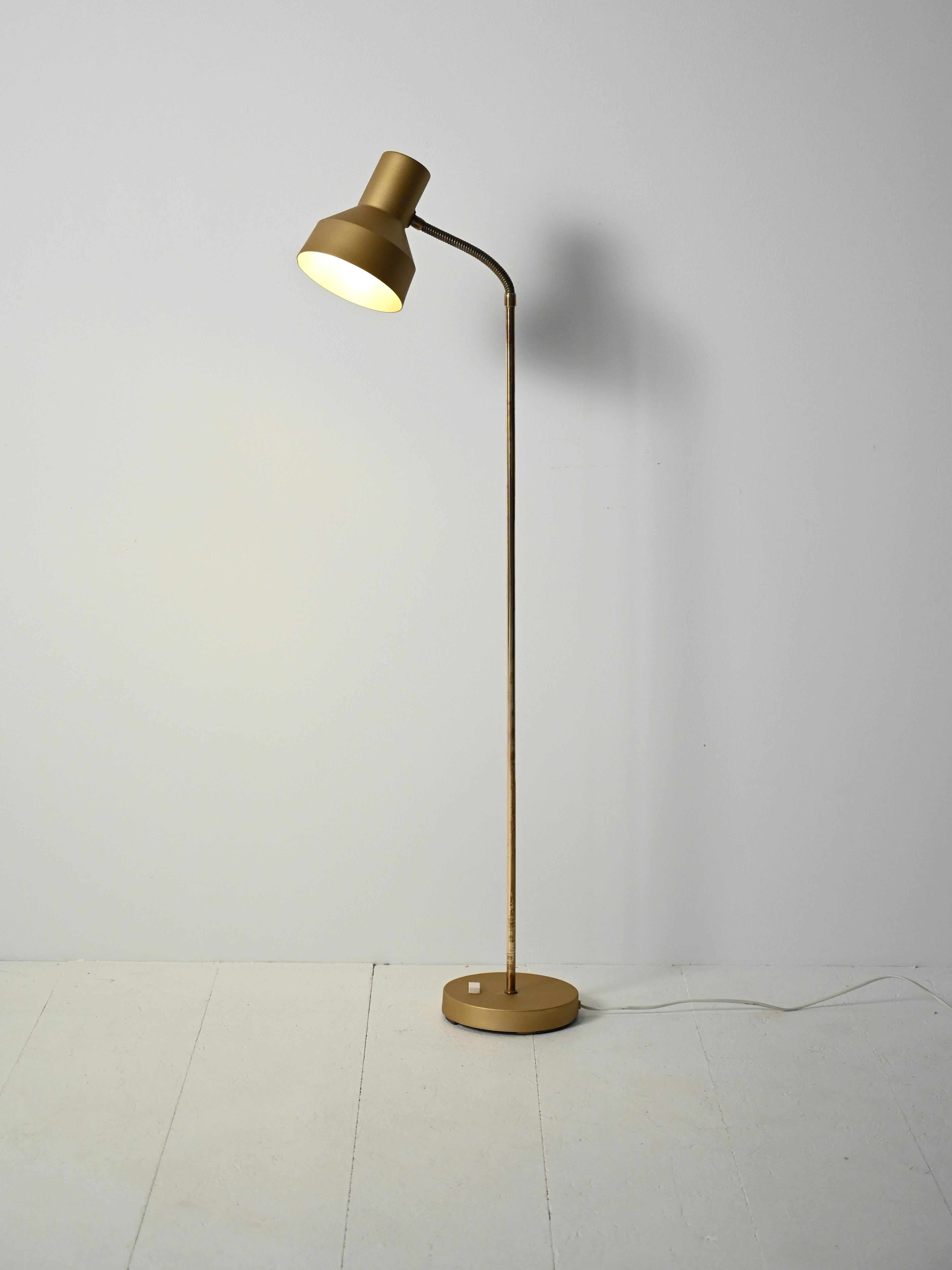 Lampada anni 60/70 in metallo dorato e ottone, stelo con punto luce orientabile e base circolare.

Elegante lampada da terra in metallo cromato color oro e ottone, con testa luminosa cilindrica e braccio “gooseneck” orientabile. La linea è