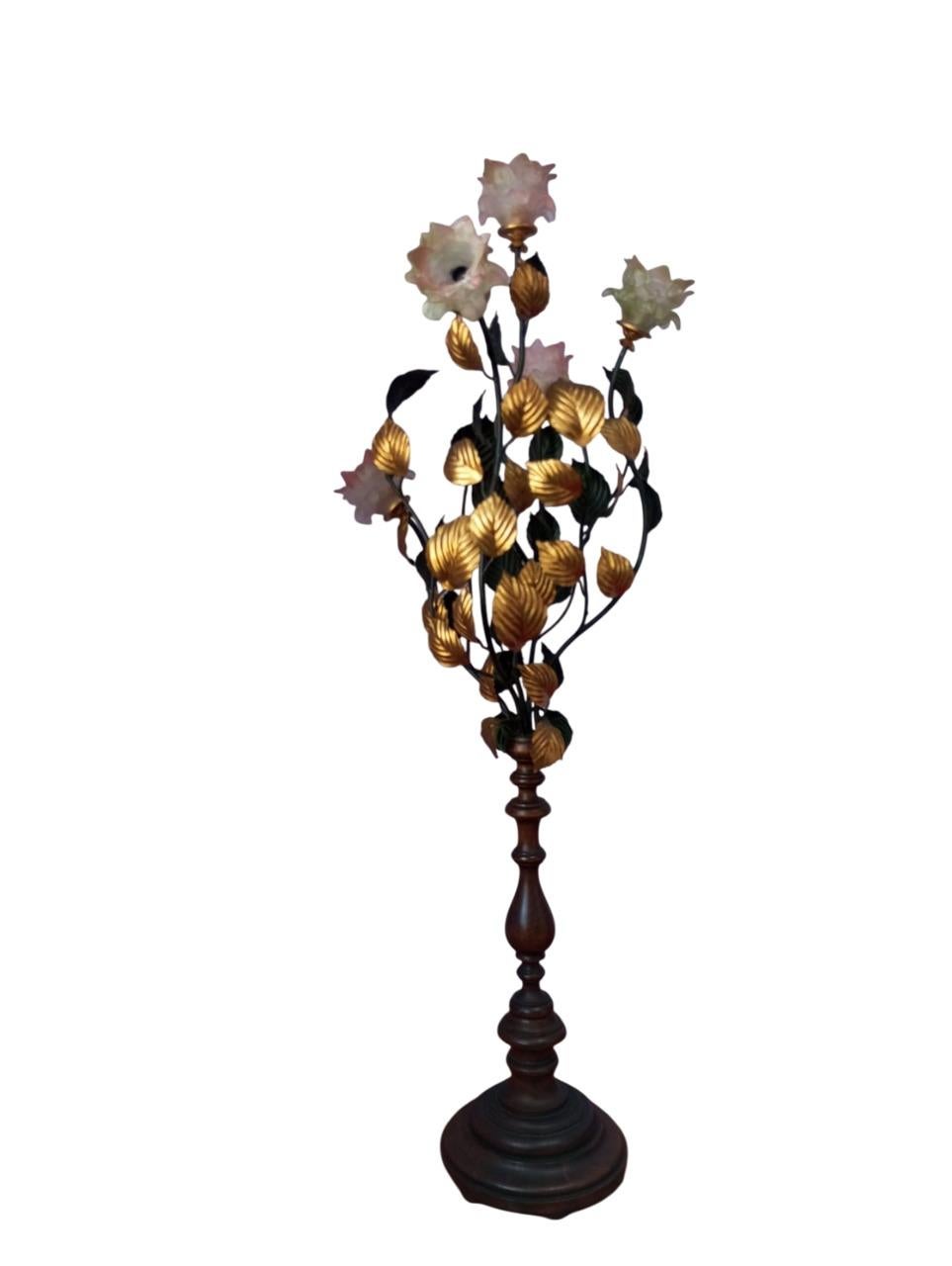 Elegant 1960s Italian-made floor lamp with sculptural structure inspired by a rose bush.
The turned wooden base supports a rich weave of metal branches, decorated with gold and burnished leaves.
The light points are enclosed within refined roses