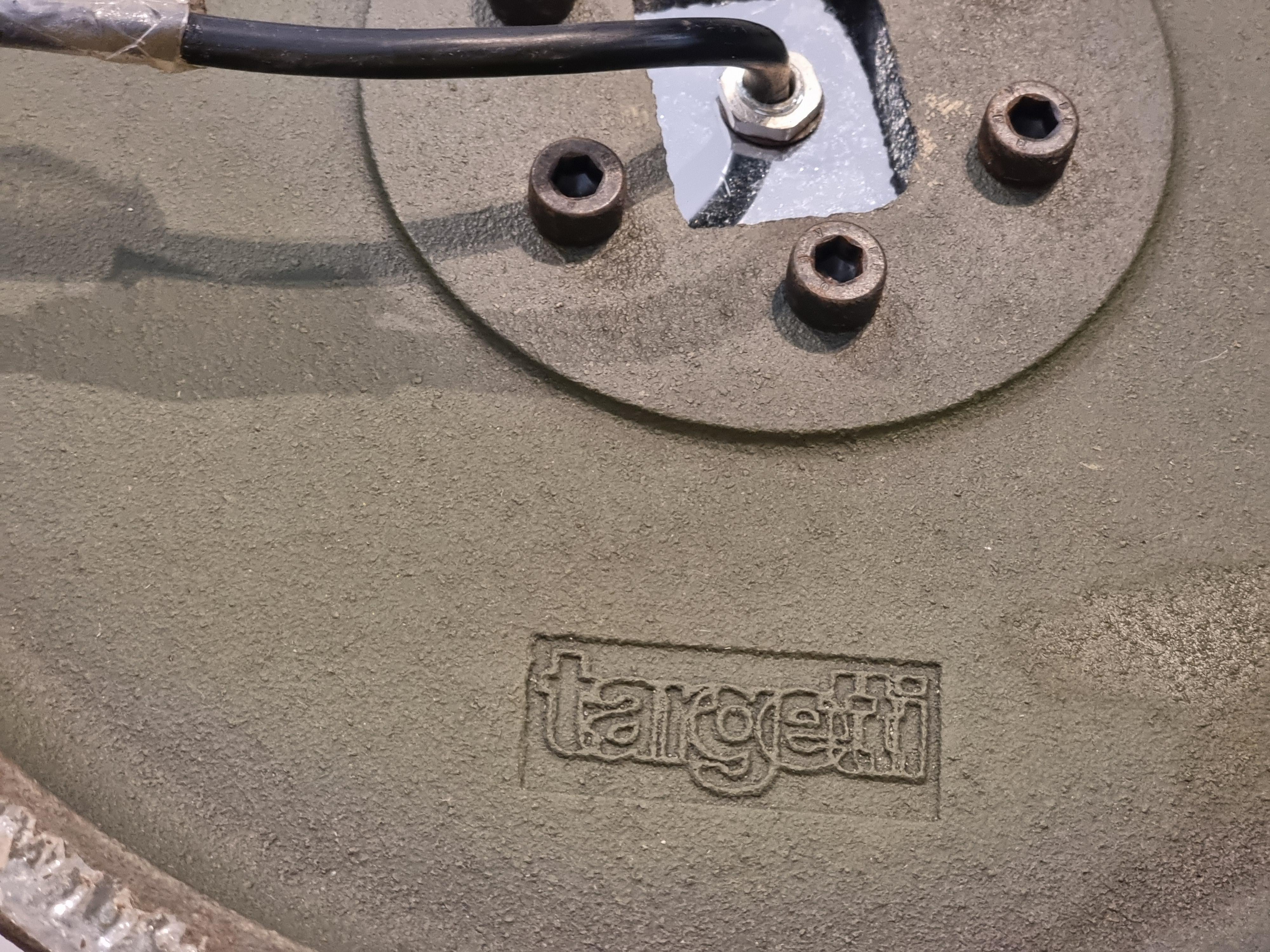 Lámpara de pie de fuerte impacto escultórico, con la marca Targhetti en la base. El gran cuenco de vidrio soplado transparente/ahumado se articula en lóbulos con filamentos negro-marrón; en el centro alberga una esfera luminosa (bombilla