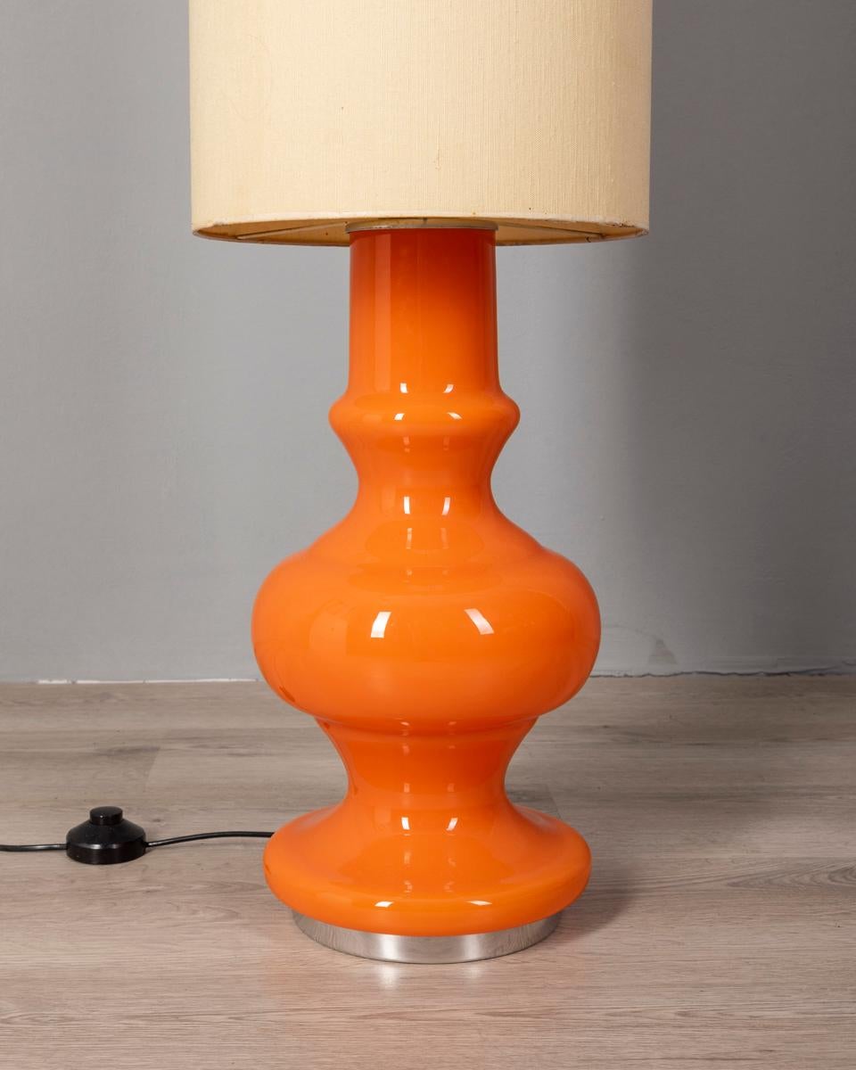 Lampada da terra con corpo in vetro arancione e paralume in tessuto, design Italiano, anni 70.

CONDIZIONI:
In buone condizioni, funzionante, può presentare segni d'usura dati dal tempo.

DIMENSIONI: 
Altezza 142 cm; Diametro 30 cm

MATERIALI: