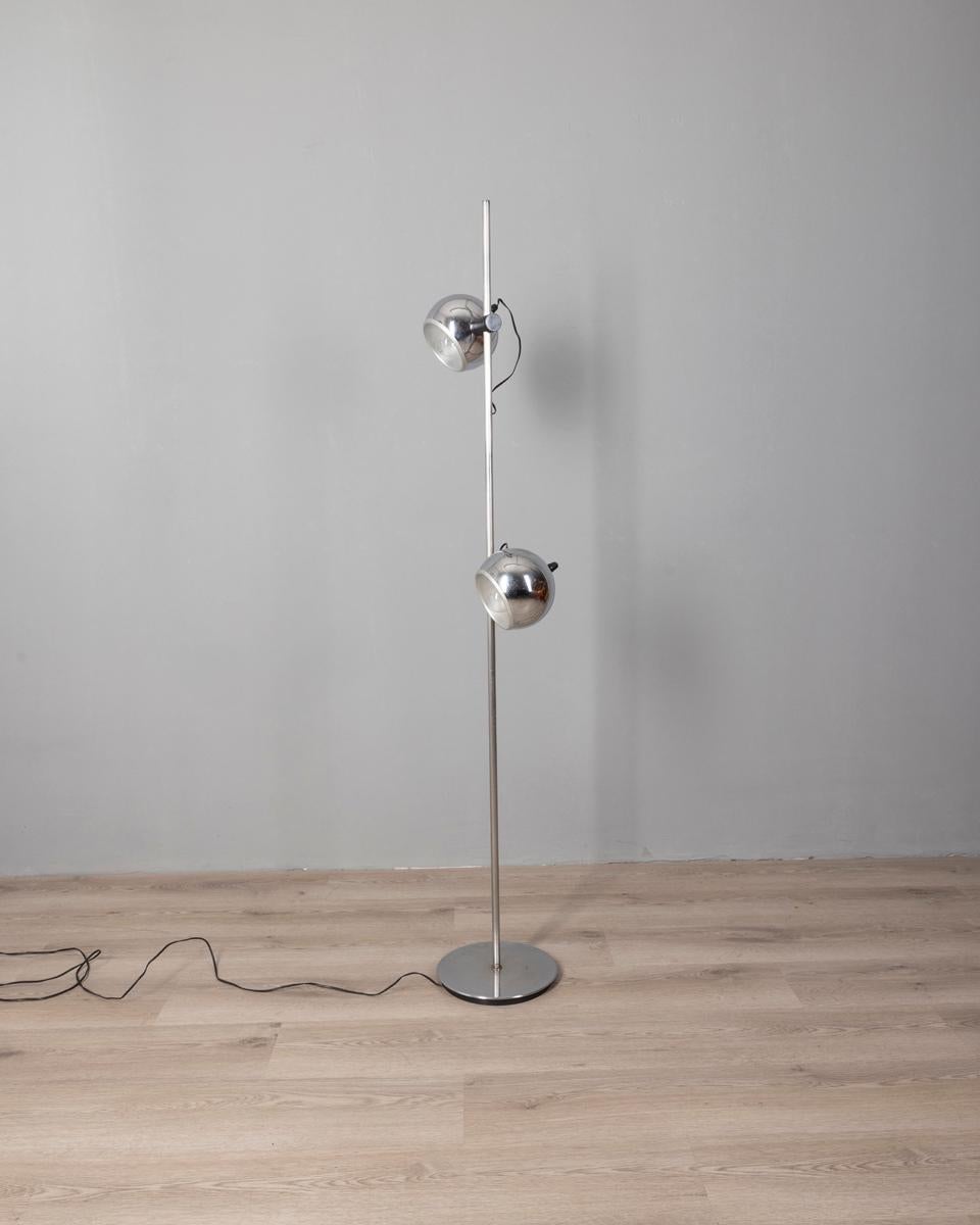Lampada in metallo cromato con due paralumi sferici regolabili, design Goffredo Reggiani, anni 70.

CONDIZIONI:
In buone condizioni, funzionante, presenta segni d'usura dati dal tempo.

DIMENSIONI: 
Altezza 162 cm; Diametro 26 cm

MATERIALI: