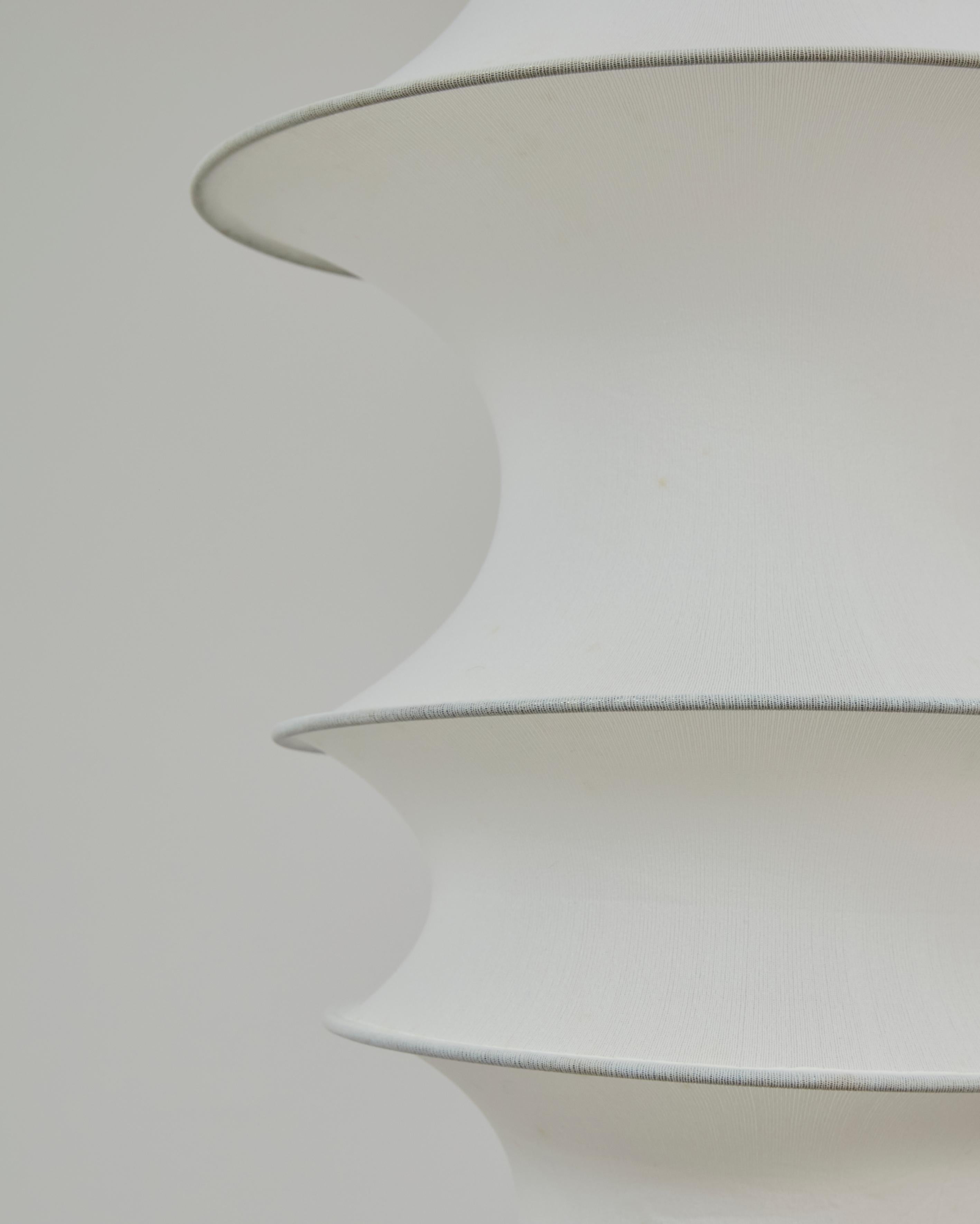 Famous Falkland hanging lamp, designed by Bruno Munari for Danese in 1964.
Composed of an aluminum reflector and a white tubular elastic mesh diffuser, supported by seven metal rings of different diameters, it represents a perfect balance between