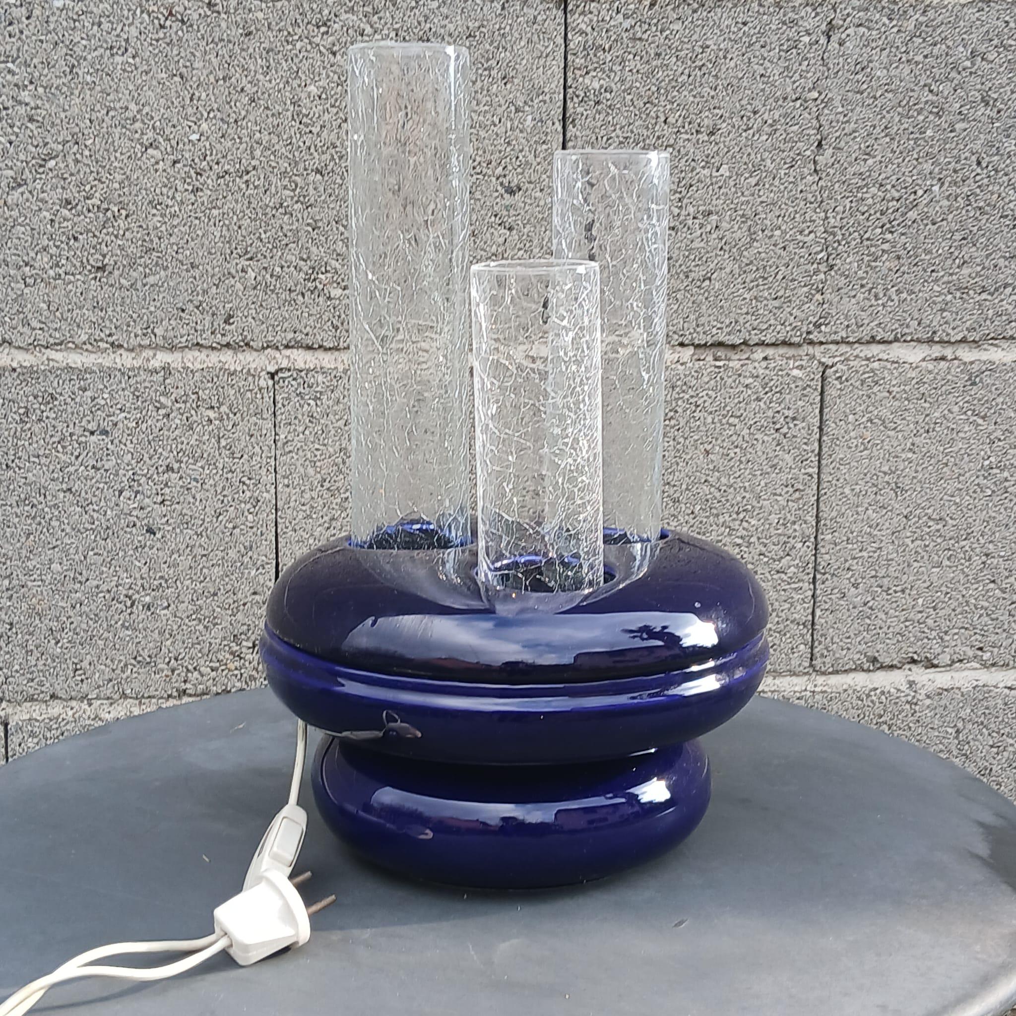 Lampe de table sculptée attribuée au designer Federico Simone, produite par Ceramiche Casarte à Torre del Greco dans les années 70. 
La base est composée de trois éléments qui constituent deux volutes en céramique scellée bleu cobalt, finition