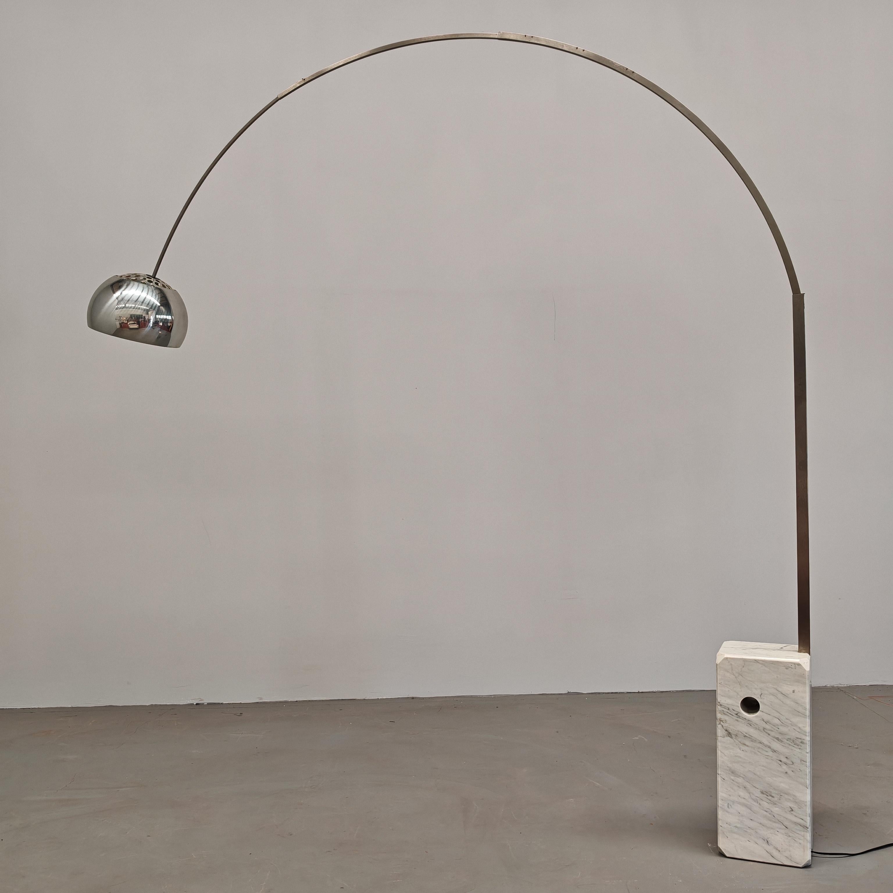 Célèbre lampadaire Arco conçu par Castiglioni en 62' pour Flos. Socle en marbre de Carrare aux angles arrondis, tige télescopique en acier satiné et réflecteur orientable en aluminium pressé, poli et zappé. 
Ce spécimen particulier date du début des