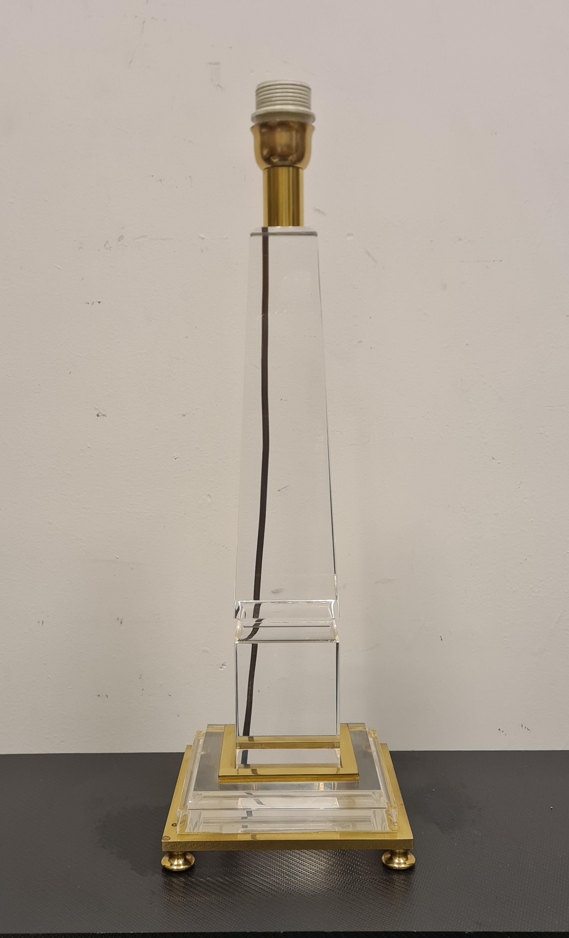 Lampe de table avec base en forme d'obélisque conçue par Sandro Petti.

Lampe raffinée en forme d'obélisque en méthacrylate et laiton avec abat-jour en tissu.

Elégante et discrète, cette lampe, dans le style Hollywood Regency typique des années