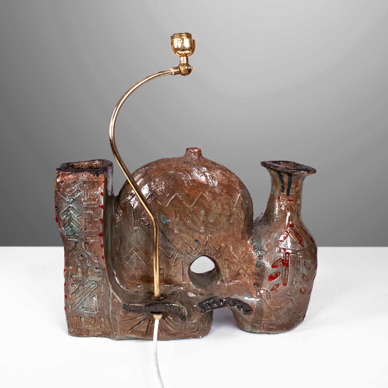 Lampe de table sculpture en céramique émaillée, objet signé Zanaga dans une édition de 20 pièces, datant des années 1950. Très bon état, abat-jour d'origine. Les mesures se réfèrent au corps de la lampe en céramique et au support en laiton, sans