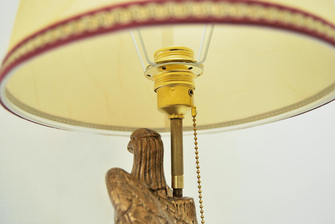 Rarissima lampada da tavolo tedesca anni '40
Questa bellissima lampada proviene dalla Germania e risale alla seconda guerra mondiale.
La colonna in legno laccato, è sovrastata dall' aquila realizzata  in polvere di marmo dorato; il tutto poggia su