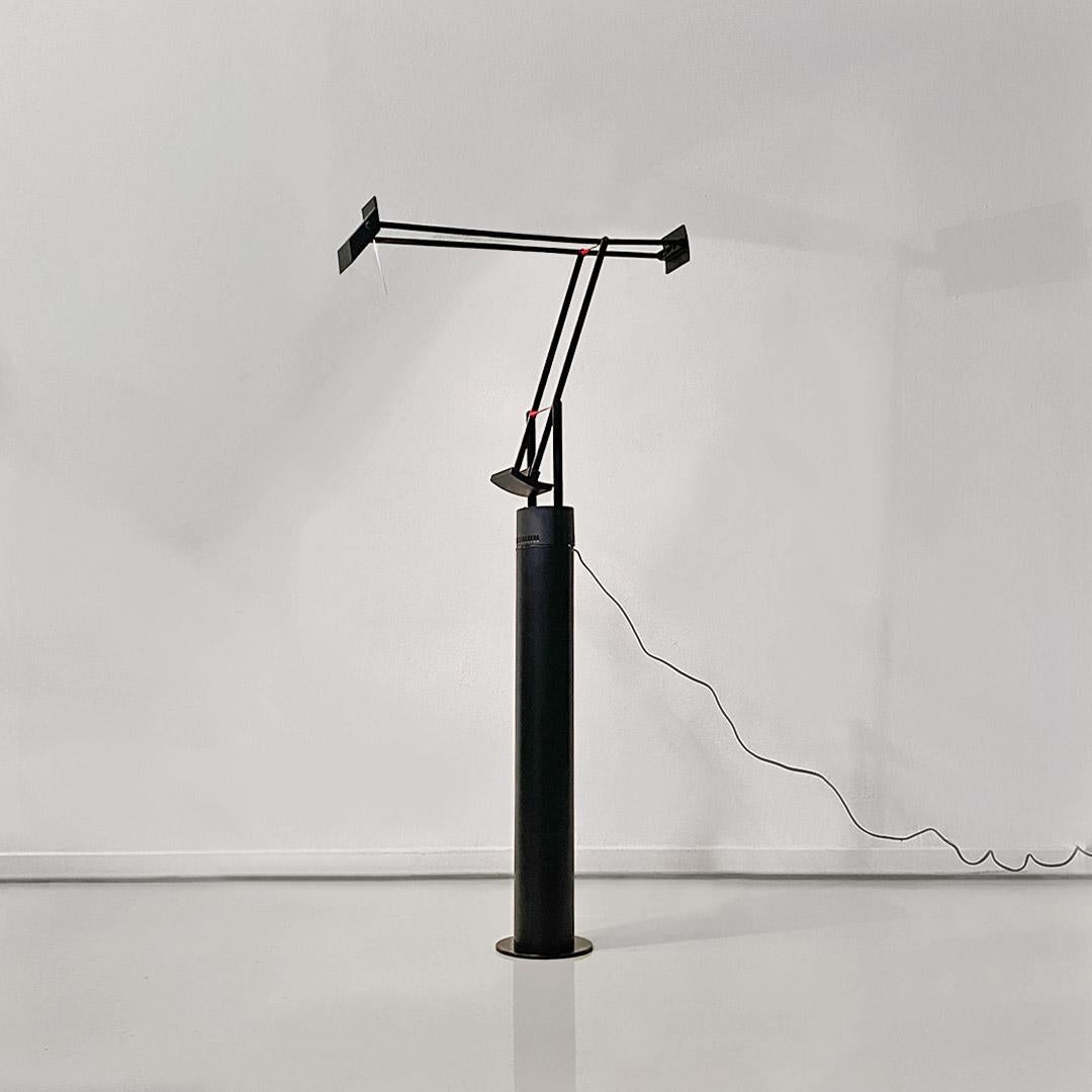 Floor lamp model Tizio, with black painted metal frame with small red details, consisting of a base and arms with two pairs of parallel slats, allowing a wide range of positions.
In this model, the base of the lamp has some plastic tabs that allow