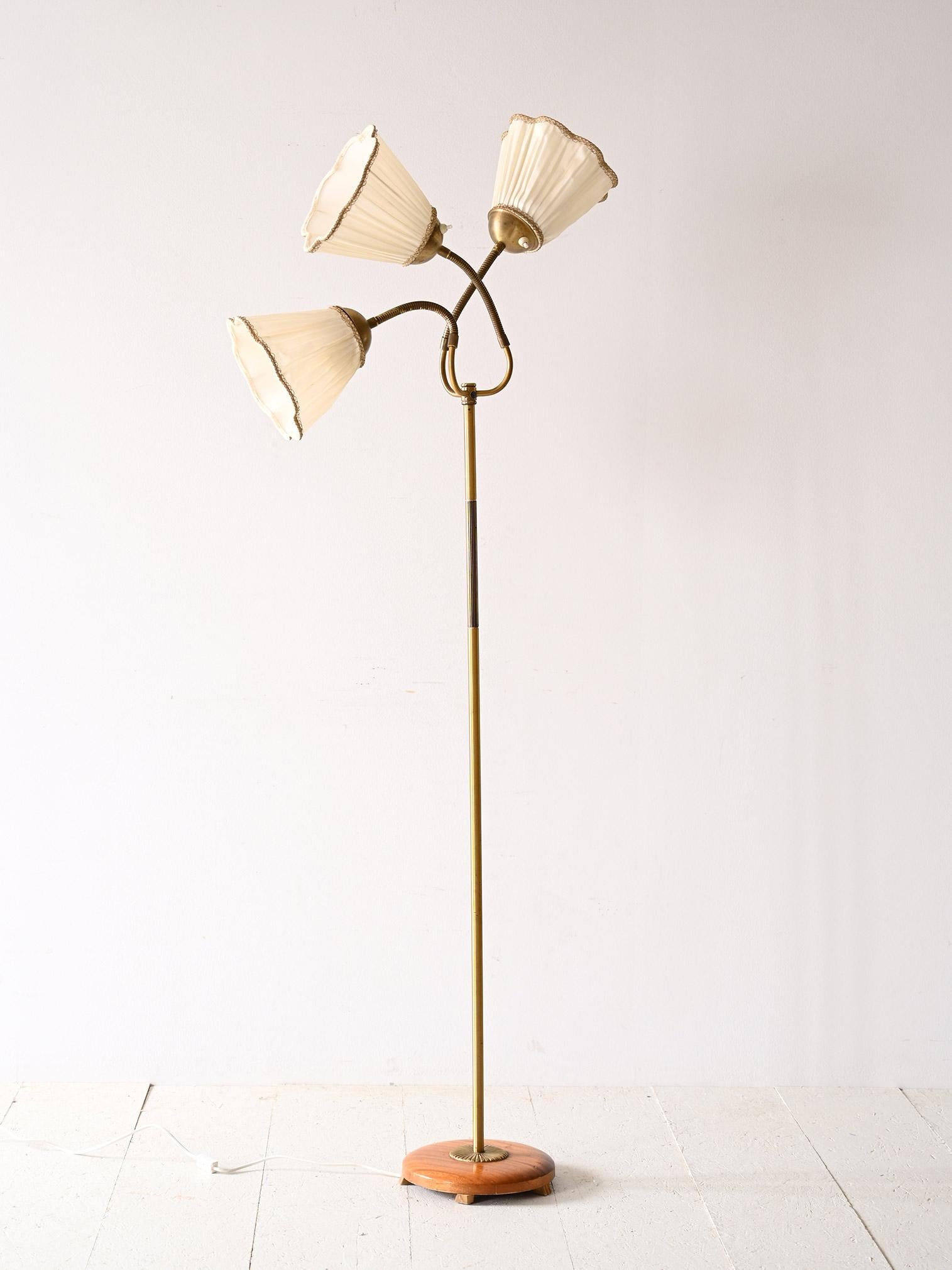 Scandinavian lamp with three adjustable heads.

This 1960s lamp stands out for its elegant and functional design, inspired by the Scandinavian style. The gold metal frame offers a touch of luxury, and the part near the lampshade is foldable,